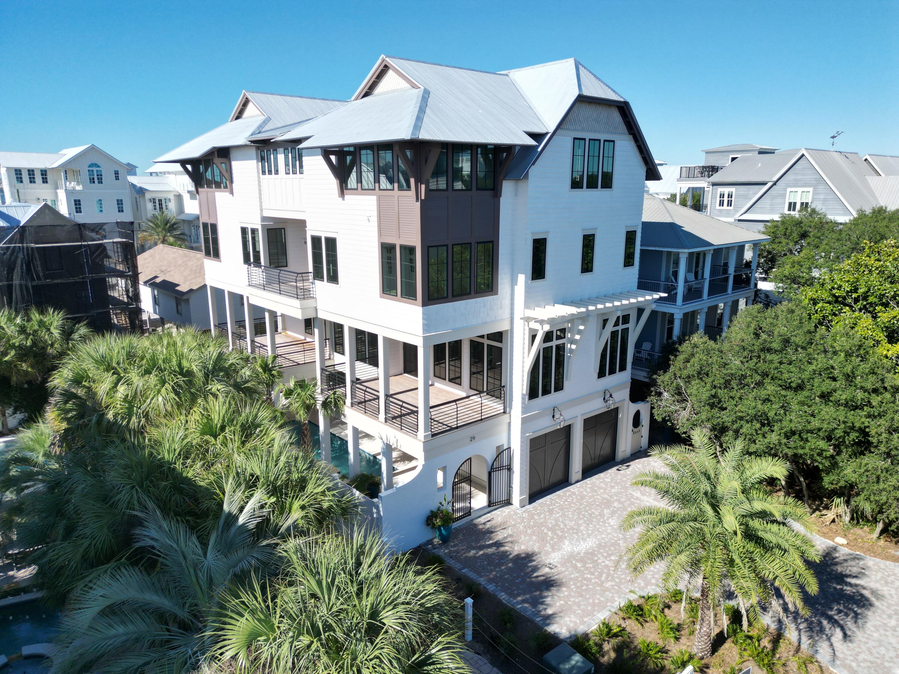 In one of the most coveted locations in Old Seagrove, just 1 home off 30A and 2 streets from the Idyllic Town of Seaside, with multiple beach accesses to over 700 feet of beach that is deeded to the public only 1 minute from the front door, is this architecturally magnificent 7 bedroom, 7 full and 2 half bath, over 7,000 sq ft  just finished new home built by renowned Minchew Construction. Designed to provide an unparalleled coastal experience, every carefully curated detail resonates relaxation and luxury. Every piece of marble, quartzite, or natural stone was hand selected for its beauty and rarity. Thoughtfully designed across 4 floors, each level caters to comfort and entertainment. Enter the first floor through a gated palm tree lined tropical oasis where your whole family can enjoy lounging by the pool or relaxing in the adjacent indoor gathering area with beautiful shell stone floors, shiplap, and coffered ceilings, complete with a wet bar, full refrigerator, one of 2 large laundry rooms with sink and plenty of cabinets, half bath, a private king bedroom and ensuite bathroom with beautiful artisan double sinks, quartzite counters and backsplash, contemporary cabinetry with designer hardware, and walk-in shower with beautiful tile, and an elevator that services all 4 floors. On the second floor you will be astonished by the massive 57 foot long south facing window lined open living area with 12 ft coffered ceilings centered around a custom floor to ceiling stone fireplace, a wet bar with sink, refrigerator and ice maker, beautiful ?? inch thick white oak, red oak and hickory solid wood floors (on all upper 3 levels), 2 separate 300 sq ft covered porches with inlaid wood ceilings overlooking the pool area with hook up for outdoor bbq, perfect for entertaining the whole family and friends while enjoying the gulf breezes and sunset skies, a dining room large enough to fit a table that can seat 12 and a chef's kitchen with an impressive quartzite island with plenty of space to mingle and move around, a separate full size Thermodore refrigerator and full size Thermadore freezer, a stylish high end AGA 6 burner gas stove and matching hood vent surrounded by a full wall of exquisite designer tile create a stunning statement piece. Tucked away behind the kitchen is the butler's kitchen with a pantry, lots of extra cabinets, additional prep space with quartzite that matches the kitchen island, sink, and a second dishwasher. On this floor is also a chic guest half bath. The third floor opens up to another large entertainment area with gulf views, stacking sliding glass doors to a covered balcony, flanked by 4 custom built in bunk beds on each side each with their own tv hook up, a full bathroom with quartzite counters, unique double sink and custom tile on the floors and around the tub/shower combination, and another full laundry room with hook ups for 2 sets of washers and dryers and closet.  On this floor are 2 plush primary bedroom corner suites with gulf views and luxurious natural light-filled ensuite bathrooms with double designer sinks, quartzite counters, high end cabinets with designer hardware and lighting, beautifull custom tile floors, one with a large zero entry walk-in shower with double shower heads, a third separate hand held attachment and tile bench, and the other with a zero entry walk-in shower room with a soaking tub; both have large walk-in closets with custom wood built-ins. On the fourth floor on either side walk through double doors into each of the 2 additional spacious primary, also corner, suites with gulf views, elegantly designed ensuite bathrooms, and large walk-in closets with custom wood built-ins. On this floor are also two additional large guest bedrooms with gulf views that can either be additional king bedrooms, have two queen beds each, or even more bunk beds. These bedrooms share a bathroom with gorgeous natural stone counters, and a stylish soaking tub. Hard to find in our area, this home has plenty of space for everyone to park with an oversized 2 car garage and brick pavered driveway with space for an additional 4 or 5 cars. Whether looking for a luxury primary or secondary home on 30A just steps to the beach that is large enough to accommodate your extended family and friends or a lucrative vacation rental investment, or both, this home is definitely one you will want to see. Rental income potential and cost of ownership information is available. The home is currently in the process of being furnished. The designer tile throughout and hand selected quartzite, marble and natural stone pieces used for all the counter tops in the home are spectacular and you will definitely want to see it, so please check back soon for new photos.