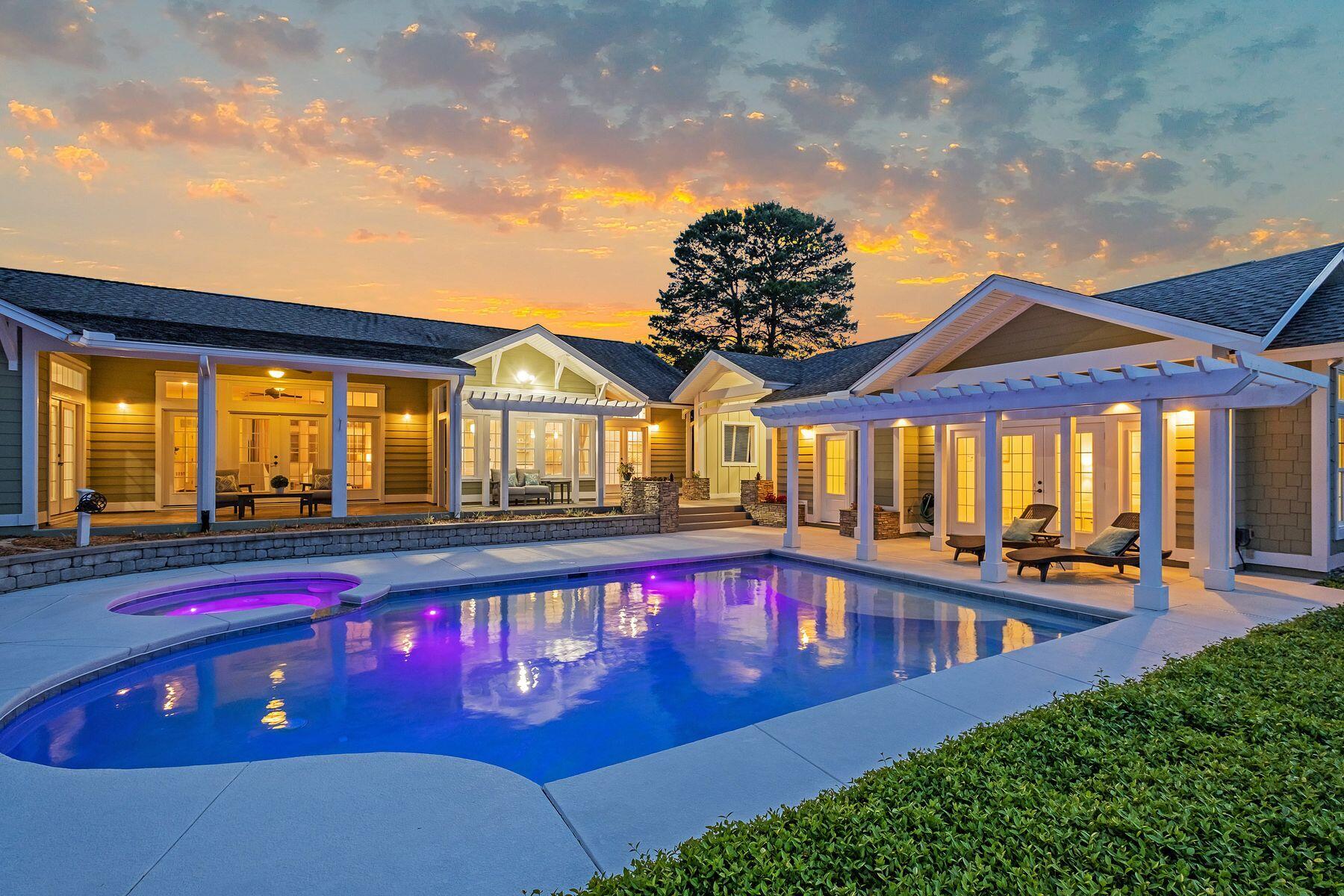 Situated on a mature half-acre lot on a quiet cul de sac, this elegant home boasts majestic lake and golf views. Enjoy an elevated and serene setting that captures this Florida cottage style with coastal design and color palette.  Follow the brick pavered driveway to an oversized three car garage and a flagstone pathway leading to the impressive covered entrance. Inside, this beautiful home exceeds expectations with gleaming hardwood floors, energy-efficient windows, custom drapes and a wall of custom bookcases for displaying family photos and treasures. Bathed in natural light, the open floor plan is ideal for entertaining. There is a wet bar and a generous chef's kitchen with a large granite-topped breakfast bar ideal for laying  hors d'oeuvres before dining.