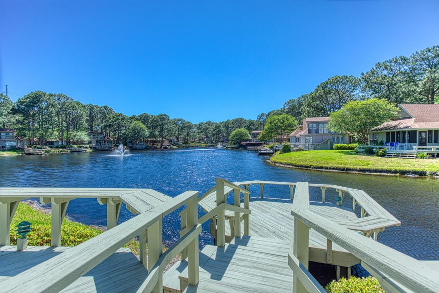 QUITE POSSIBLY THE NICEST VIEW WITHIN THE FAIRWAYS. Enjoy morning coffee and/or an evening beverage from the deck, dock or 2nd floor patio that overlooks the entire lake. This Florida courage also offers a partial BAY VIEW just pass the golf course. The enclosed patio adds a bonus room which makes this home larger than the standard 3 BRs within this subdivision. All bathrooms have been tastily remodeled recently. Additional updates include porcelain plank flooring, new HVAC (2017), separate laundry room, Plantation shutters. Amenities include 4 golf courses, bike paths, tennis courts, 4 swimming pools and the largest PRIVATE BEACH within the area. The included 6 PASSENGER GOLF CART will make driving to the Village of Baytowne Wharf, the Beach or any other event even more fun!