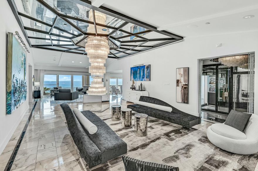 Calling all maximalist lovers, this is the condo for you! This glitzy penthouse with over 4000 sf has old Hollywood glamor, with a modern touch, that is nothing short of spectacular. Views reign supreme in this beachfront palace in the sky, which has gulf views from 6 of its rooms. In addition, this 3 bedroom condo has a bonus room that could easily become a 4th bedroom on the gulf side. Some original features include shimmering hand-blown glass chandeliers, Italian etched mirrors, 3D wallpaper, bar room with wine storage, and marble floors throughout. A recent addition is a chef's kitchen with quartz counter tops, new Dacor/Bosch appliances, and butler's pantry.  This condo is perfect for anyone who entertains with large rooms flowing from one to the other, and a spacious balcony.