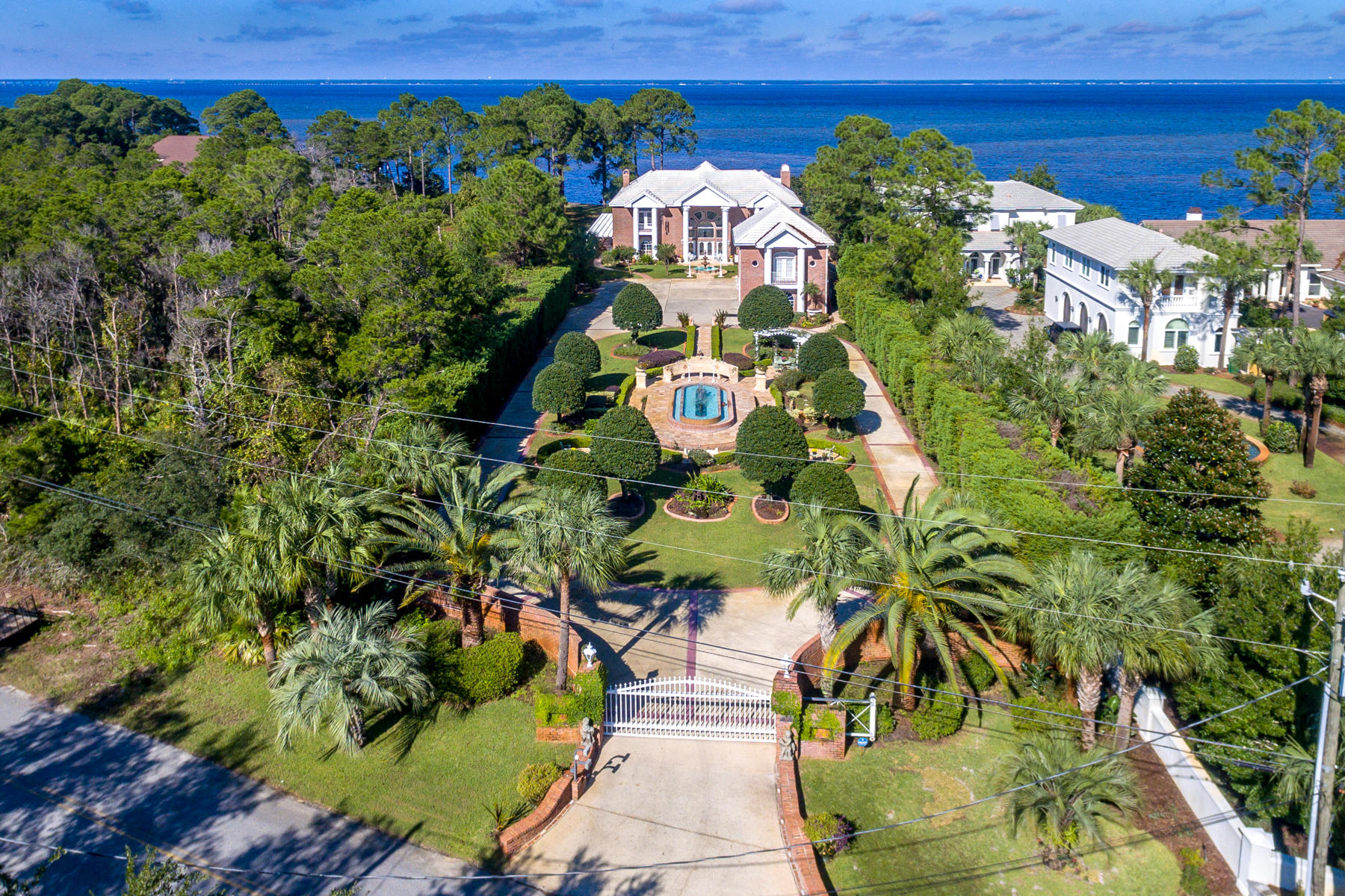 Dolce Vita is calling your name. This magnificent villa boasts over 8400 sq. ft of luxurious finishes. Upon Entering the private gates of this exquisite estate, you will feel as though you have been transported to the Italian Riviera. Worlds away from the hustle and bustle of Destin and tucked behind stately brick walls, lies the most immaculate grounds and gardens overlooking the beautiful Choctawhatchee Bay. Winding pathways lead you through thoughtfully arranged courtyards that overlook gorgeous mosaic fountains, marble statues, hand painted pottery, a stunning marble gazebo and beautiful carved marble benches.The architecture of the home is that of a colonial revival with Italian inspired features throughout. Eight stately and grand columns greet you as your approach the front entry.