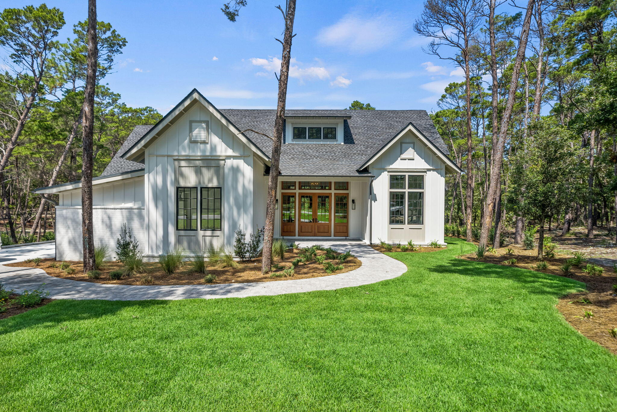 OPEN HOUSE Sunday, 8/24 12-3pm! This stunning NEW CONSTRUCTION, single level home in Wild Heron is where modern craftsman design meets resort-style living. Welcome to a home where timeless design and modern luxury meet coastal serenity--just minutes from 30A and nestled within the gates of Wild Heron, one of Panama City Beach's most desired, fast growing communities on the shores of Lake Powell.Thoughtfully designed and construction just completed, this highly desirable, single-level masterpiece spans 3,300 square feet under roof and offers 2,401 square feet of interior living and over situated on a generous .37-acre homesite that backs up to conservation area offering both privacy and peaceful views. From the moment you step through the 8' solid Mahogany French doors, you're greeted by a sense of understated luxury. As you enter, you're greeted by a showstopping 24' cathedral vaulted ceiling in the living room, 12' ceilings flowing throughout, and an open concept anchored by a natural gas fireplace. Arched doorways add architectural charm and warmth, while modern, black Andersen windows and French doors to the patio flood the space with natural light. Step outside the living area to your private oasis where you'll find your own private, saltwater pool surrounded by a pavered deck, lush landscaping, and a vaulted, covered back porch plumbed for an outdoor kitchen.
The open-concept layout is both inviting and functional, perfect for effortless entertaining and everyday living. Enjoy white oak flooring throughout, along with a curated palette of classic tile selections in the bathrooms, mudroom, and a timeless black-and-white checkered tile mud room and butlers pantry.
The kitchen is timeless and classic featuring white shaker custom cabinetry on the perimeter with a warm white oak wood island, Quartz countertops, and a full suite of Bosch appliances, seamlessly blending style and utility. A spacious butler's pantry off the mudroom and kitchen adds even more prep space with built-in shelving, generous counters, and a beverage fridge.
The primary suite is a true retreat with stunning conservation area views, shiplap clad vaulted ceilings, a spa-like primary bath with a soaking tub, zero-entry tiled shower, and a custom walk-in closet with double vanities paired with modern tile selections. With four bedrooms and three baths, this home offers a split floor plan that prioritizes privacy and comfort. All bedrooms offer walk-in closets, three bedrooms of the four bedrooms feature vaulted ceilings and a generous size Jack n' Jill bath with separate vanity areas allow for the best use of the third bathroom.
The 2-car garage offers tall ceilings for expanded storage and an EV-car charger for convenience of those with electric vehicles or golf carts. Crafted with enduring materials, brick and Hardie siding, this home captures the charm of classic craftsman style with the function and efficiency of modern construction with a coastal elegant twist.
Spanning 734 pristine acres along the shores of Lake Powell, Florida's largest coastal dune lake, this extraordinary community invites residents to slow down, breathe deeply, and savor the beauty that surrounds them. Morning strolls along miles of tree-lined walking trails, afternoons spent lounging at the resort-style lakefront pool, and evenings by the boathouse pavilion watching the sun set over the water, this is the rhythm of life here. With access to a community dock, fitness center, playground, and the opportunity to lease private boat slips with power lifts, Wild Heron was built for those who crave both adventure and serenity.
For those seeking the ultimate in exclusivity, Watersound Club membership elevates the experience with multiple private Club opportunities. In Wild Heron, enjoy the challenge of Shark's Tooth Golf Club, a Greg Norman-designed 18-hole masterpiece. Unwind at the clubhouse, sharpen your swing at the driving range, or hit the courts for a game of tennis.