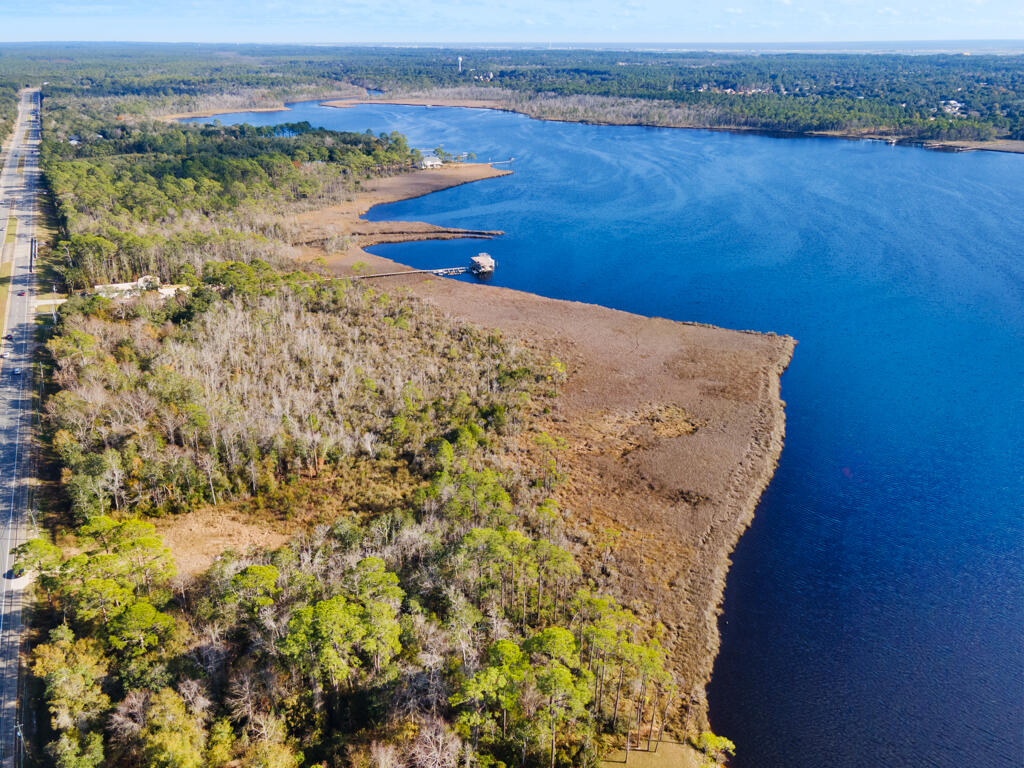 Make these 8 acres of wooded, waterfront property along Hwy 87 in Navarre yours today! Located just minutes from Navarre Beach, and a short drive to I-10 for easy commuting to all surrounding areas and military bases. With no HOA and public water and utility access available out front for you to get connected to and build your waterfront getaway, your own private fishing hole, or just your very own spot to catch the sunsets on the bay!