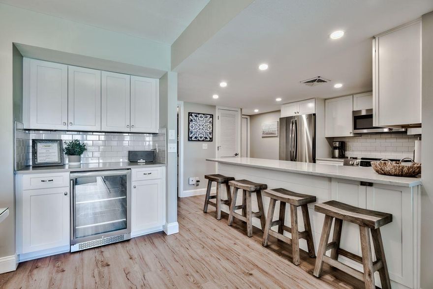 This first-floor walk-out unit is a great opportunity for someone looking for a vacation home or rental investment that's been completely updated. Fresh light decor, new wood-look flooring and modern furnishings present a contemporary condo filled with natural light. The remodeled kitchen has gleaming white cabinets, quartz counters and a full range of stainless appliances. Four barstools are lined up, ready for drinks and snacks at the high-top bar. There's a spacious dining area for entertaining and a built-in wet bar with a wine refrigerator ensuring an endless supply of perfectly chilled drinks. The updated living area has tasteful new furniture for sitting back and enjoying the view. The unit includes a private terrace for dining with views of the green space and tennis courts. Two large bedrooms and two updated bathrooms can easily accommodate six guests. There's step-free access to your parking space, pool and onsite amenities. Holiday Surf and Racquet Club lives up to its name with gulf-front deeded beach access, a heated lagoon pool, tennis courts, shuffleboard, fitness room, laundry, game room with pool table and ample green space keeping everyone happily entertained. Located on Holiday Isle, this beautifully updated condo is a world away from the traffic and bustle of Destin. You'll find plenty of restaurants and shops within a five-minute drive of the resort and Destin Harbor is the perfect place for an afternoon stroll. This condo has a strong history of rental income, consistently generating more than $55,000. But once you've seen it, you might just want to keep it for yourself.