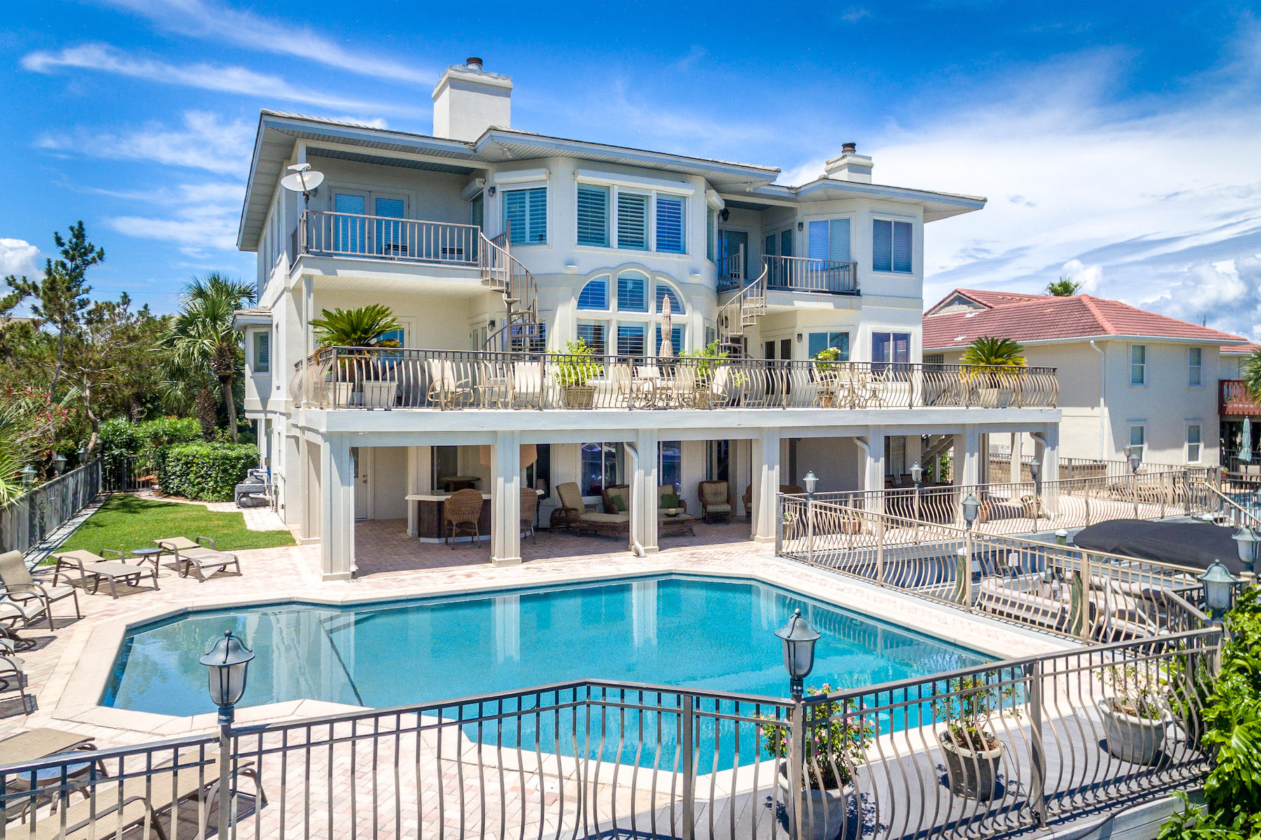 Masterly updated, waterfront estate on the deep, boating waters of Destin's renowned Holiday Isle. Designed for authentic coastal living, this 6,294 sq. ft. home claims an additional 6,000 sq. ft. of outdoor hardscapes right on the canal. Its exceptionally large dock features two boat slips, one with a boatlift, and dockage along the seawall, accommodating three vessels up to 52 ft in length. Inside and out, this home boasts stately proportions and room for a crowd. The private, heated 30 x 25 ft pool is one of the largest on Holiday Isle. Inside, the updated, transitionally designed interiors feature renovated baths, a double-height great room, an ultra-luxurious chef's kitchen, private guest quarters, and elevator. Warm-toned, neutral palettes emphasize the vivid views of the canal and Gulf. The kitchen is designed for both form and function. Custom woodwork, hardwood floors, and granite countertops bring a traditional elegance to this space, while top-quality appliances, an intuitive layout, and a pass-through breakfast bar are designed for some serious entertaining. Appliances include a separate gas and electric cooktop; Viking refrigerator, Viking gas stovetop, Jennaire convertible gas grill, and Kitchenaide electric stove top with range hood. The main master suite is glamorous and spacious. A bay window sitting area with fireplace and private balcony offer peaceful views of the canal. A renovated en suite with dressing area, soaking tub, and walk-in shower is evocative of a relaxing spa. This home also features a junior master suite with separate sitting area on the second story. A bonus room on the first floor provides sleeping quarters, an entertainment area, and a full bath with whirlpool tub accessible from the pool. A 2-door and a 1-door garage collectively accommodate four cars. Home improvements include select new appliances, refinished hardwoods, four renovated baths, new lighting design, new hot water heater, remodeled laundry room, new HVAC units, and much more. The pool was resurfaced in 2014 and includes a 10-year warranty. Located between the Harbor and Gulf of Mexico, the 3-mile peninsula of Holiday Isle is characterized by its pristine beaches, friendly sidewalks, and ever-changing Harbor views.