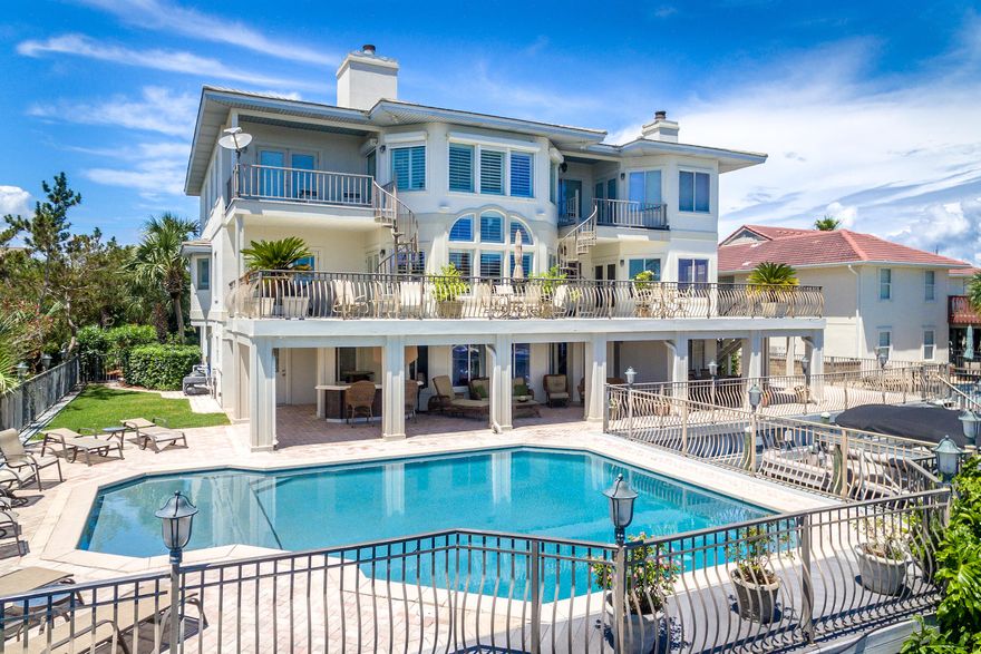 Masterly updated, waterfront estate on the deep, boating waters of Destin's renowned Holiday Isle. Designed for authentic coastal living, this 6,294 sq. ft. home claims an additional 6,000 sq. ft. of outdoor hardscapes right on the canal. Its exceptionally large dock features two boat slips, one with a boatlift, and dockage along the seawall, accommodating three vessels up to 52 ft in length. Inside and out, this home boasts stately proportions and room for a crowd. The private, heated 30 x 25 ft pool is one of the largest on Holiday Isle. Inside, the updated, transitionally designed interiors feature renovated baths, a double-height great room, an ultra-luxurious chef's kitchen, private guest quarters, and elevator. Warm-toned, neutral palettes emphasize the vivid views of the canal and Gulf. The kitchen is designed for both form and function. Custom woodwork, hardwood floors, and granite countertops bring a traditional elegance to this space, while top-quality appliances, an intuitive layout, and a pass-through breakfast bar are designed for some serious entertaining. Appliances include a separate gas and electric cooktop; Viking refrigerator, Viking gas stovetop, Jennaire convertible gas grill, and Kitchenaide electric stove top with range hood. The main master suite is glamorous and spacious. A bay window sitting area with fireplace and private balcony offer peaceful views of the canal. A renovated en suite with dressing area, soaking tub, and walk-in shower is evocative of a relaxing spa. This home also features a junior master suite with separate sitting area on the second story. A bonus room on the first floor provides sleeping quarters, an entertainment area, and a full bath with whirlpool tub accessible from the pool. A 2-door and a 1-door garage collectively accommodate four cars. Home improvements include select new appliances, refinished hardwoods, four renovated baths, new lighting design, new hot water heater, remodeled laundry room, new HVAC units, and much more. The pool was resurfaced in 2014 and includes a 10-year warranty. Located between the Harbor and Gulf of Mexico, the 3-mile peninsula of Holiday Isle is characterized by its pristine beaches, friendly sidewalks, and ever-changing Harbor views. 
