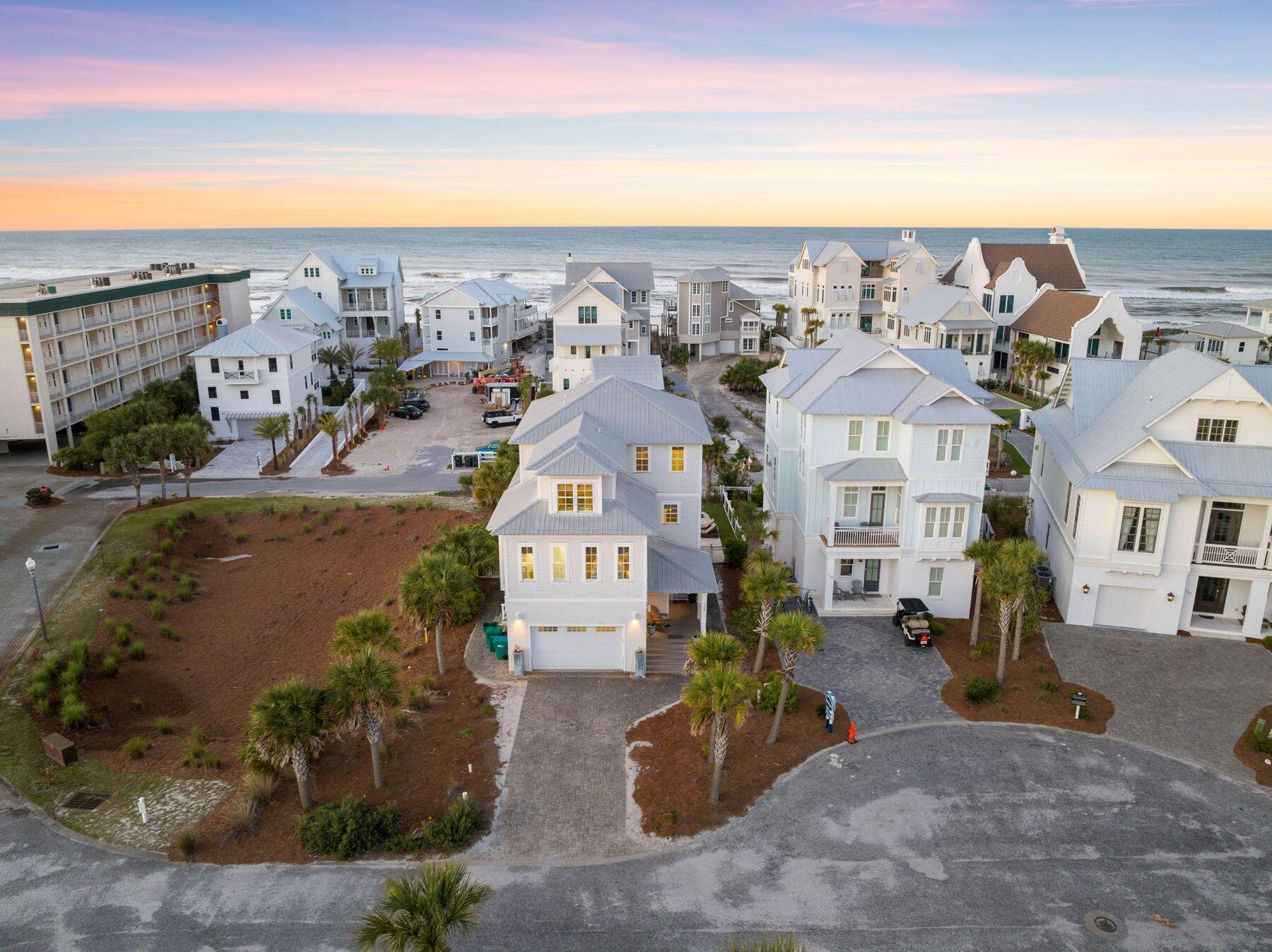 Nestled in a tranquil cul-de-sac, only a block away from the beach and the Gulf of Mexico, this expansive beach house captures the essence of the sought-after 30A lifestyle. Each of its three floors features covered balconies that offer sweeping views of a private saltwater pool and the pristine, emerald waters of the Gulf extending into the horizon. Park your car on the driveway in front of the two-car garage and head up the steps to the porch. The first floor has a beautiful guest bedroom and a game room with TV and bar for socializing. It flows seamlessly out to a furnished outdoor lounge complete with a swing bench overlooking the heated pool and private fenced yard. The second floor is the main living area for mealtimes and social gatherings with hardwood floors and shiplap ceilings in the family room. Professionally curated furniture elevates the luxurious living experience in this bright open space. Granite countertops grace the chef's kitchen and lengthy bar where evenings begin with a drink or appetizers before dinner. The kitchen has custom cabinetry, stainless appliances and everything you need to create quick snacks or elevated cuisine when entertaining. Doors lead onto a deep porch for alfresco dining beneath the gently turning fan as the sun goes down. The outdoor kitchen makes it easy to entertain with a built-in grill and refrigerator. Two comfortable guest bedrooms are located on this level. Ascend to the top floor, where a luxurious master suite, a second sitting area with a wet bar/coffee station and a bunk room welcome guests. The master bedroom offers stunning gulf views to wake up to. It adjoins a large bathroom with an oval tub and twin marble vanities. Lush turf and paved patios invite you to relax around the heated saltwater pool. Challenge family and friends to a game of ping pong or cornhole and toast s'mores around the fire pit after dark. This beautiful home would make an excellent full time residence for beach lovers but also offers a great investment opportunity. Rental income in 2023 exceeded $280,000. Located in the desirable Eastern Lake area of Seagrove, the home is within easy reach of elegant boutiques, cafes and seafood restaurants. Hiking opportunities can be enjoyed in Deer Lake State Park or explore the area on two wheels along the nearby Timpoochee Trail. 