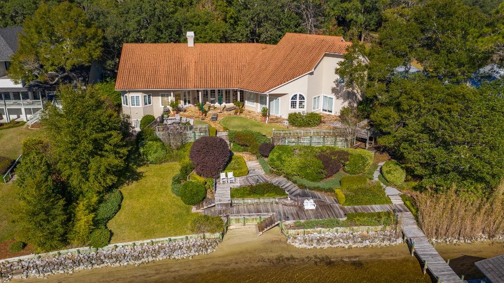 MAGNIFICANT waterfront estate located on a .83 acre lot with 150' on picturesque Rocky Bayou!! This home was architecturally designed to offer AMAZING Bayou views from almost every room while allowing for an abundance of natural lighting. This masonry stucco home was upgraded with a stone coated metal roof in 2014 and 2 Trane HVAC systems in 2019. The open floorplan allows for an abundance of natural light and features multiple living areas, formal dining room, chefs kitchen, master suite, gym, office/library and an additional bedroom suite downstairs and two additional bedroom suites upstairs. Home upgrades include a solid cherry entry door, Pella windows and exterior doors, marble and granite foyer, oak, birch and stone tile floors, high ceilings, deep baseboards, extensive millwork,