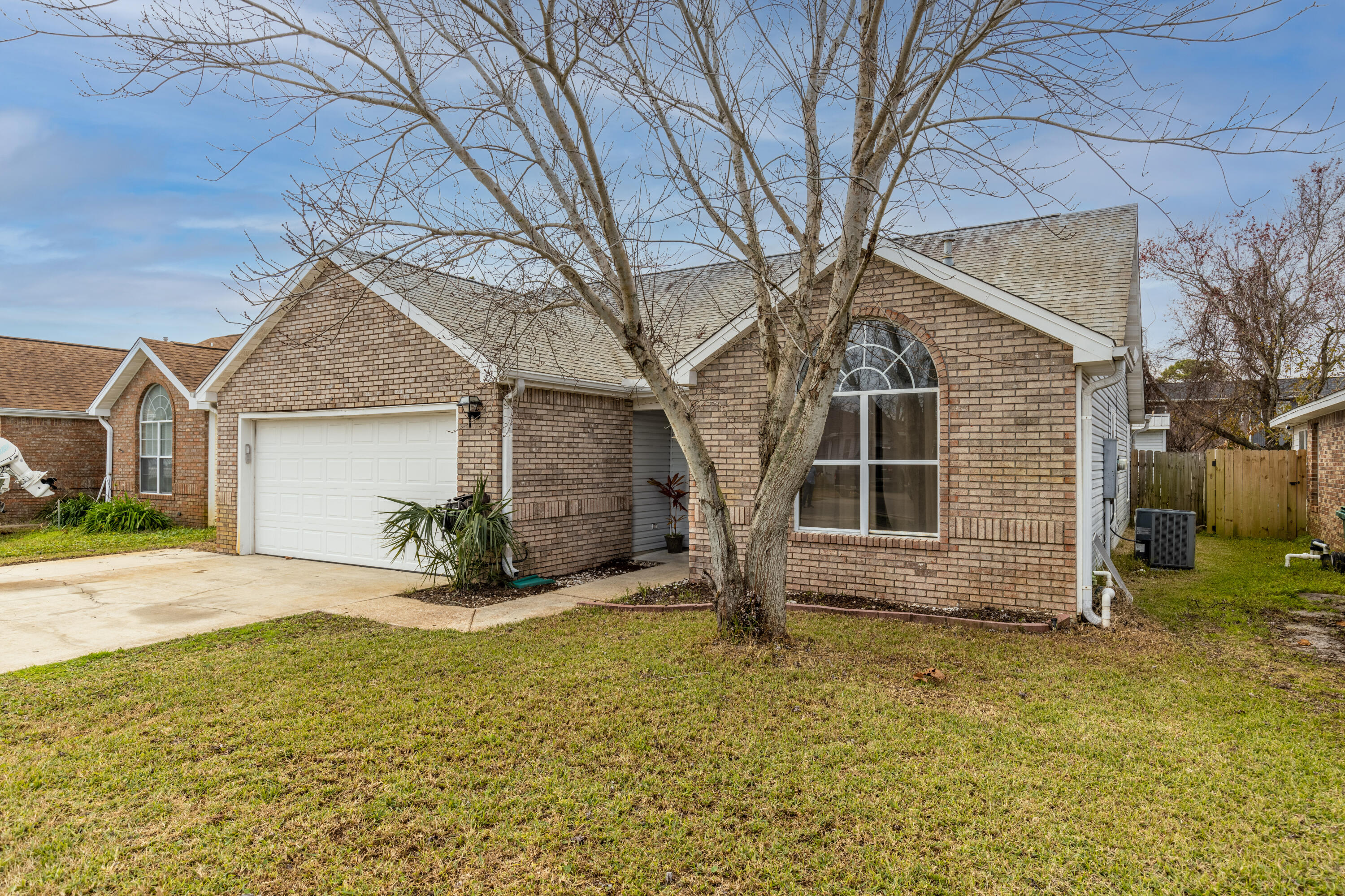 This inviting single family, three-bedroom home is situated on a friendly street with no HOA in the heart of Destin. Upon entering you'll immediately notice the high vaulted ceiling and laminate flooring throughout. The split floorpan and stylish updates provide the ideal blank slate for any design aesthetic. The home also boasts a two-car garage with an extra wide driveway for ample parking and an enclosed Florida room with a covered back patio ideal for kids, pets and entertaining. You'll really enjoy the privacy of the fenced backyard that also includes a large storage building. But the ultimate luxury of this home is it's convenient access to the elementary school as well as Destin's best shopping and dining and the natural beauty of Destin's inland bayous, beaches, and Crab Island
