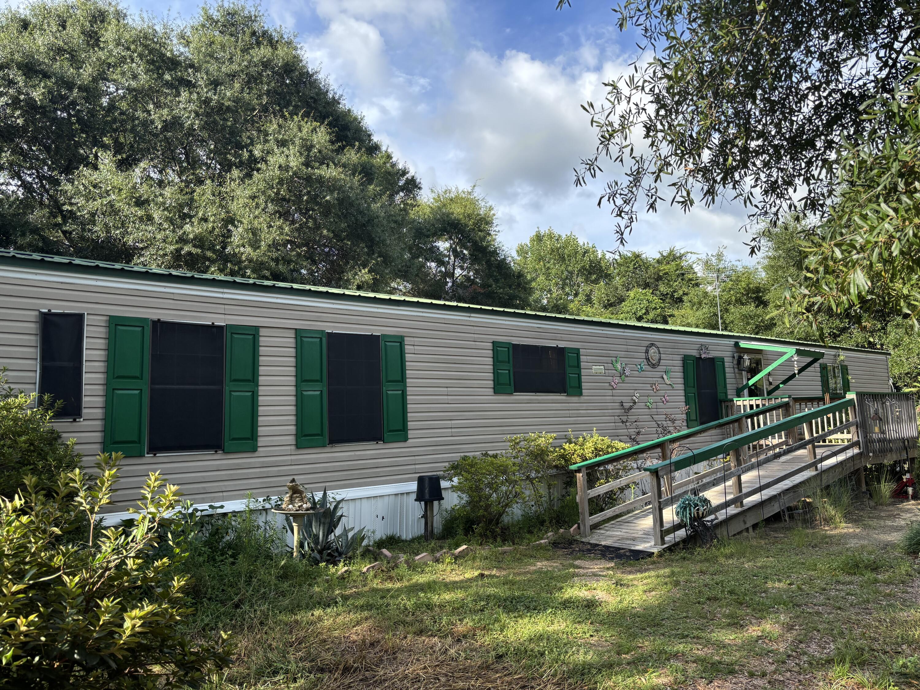 Welcome to this charming manufactured home situated on 2 spacious lots, totaling nearly 1/2 an acre. Enjoy peaceful mornings on the front porch or back deck, ideal for sipping coffee and taking in the surrounding nature. With a 16x16 building with metal roof can serve as a workshop or hobby space.The fully fenced yard offers privacy and flexibility whether you're considering adding a pool or creating a garden retreat. Large Concrete pad could be an RV spotInside, the home offers an excellent opportunity for customization. With a little TLC, this property has strong potential for use as a primary residence, seasonal getaway, or an addition to an investment portfolio. Conveniently located only approx. 50 min. To the beautiful South Walton Beaches, Schedule your private showing today