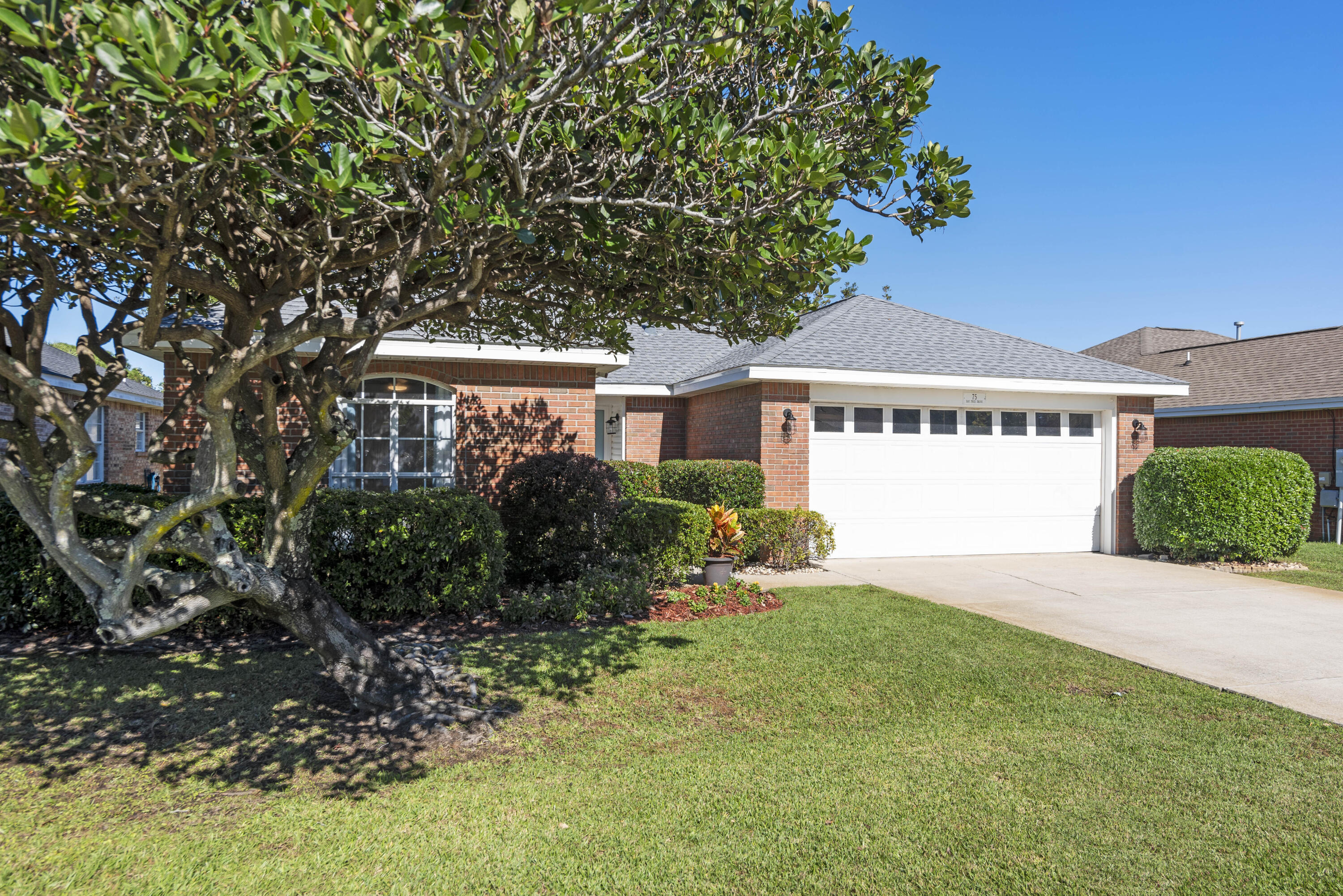 Charming one-level brick home with 2-car garage in Bayside, a great non-rental community in Miramar Beach close to the bay & beach! This home has beautiful curb appeal with nice landscaping and trees and a fantastic covered back porch and backyard offering true serenity. There are plentiful trees and added features like a garden trellis & shed. The interior offers 3 bedrooms and two baths with some unique custom updates like the beautiful white washed tongue & groove accent wall and elegant primary bath updates. The nice foyer entry opens up to a grand room with vaulted ceilings, gas fireplace & llarge sliders leading to a fantastic covered patio, an ideal spot for your morning coffee or to unwind at the end of day. There is updated flooring throughout with tile in the main living areas. There is an elegant dining area overlooking the whimsical backyard. If you fancy more casual dining, there is a breakfast bar for two. The kitchen has stainless steel appliances and artistic cabinet pulls and the 2-car garage is accessed off the kitchen. The primary suite is generously sized and features direct access to the patio, a large walk-in closet, trayed ceiling and impressive ensuite bath with updated Quartz double vanity, new cabinetry, elegant tile floors, large soaking tub for relaxing and updated tile shower with upscale tile, two niches and glass shower door. There are two guest bedrooms and a shared guest bathroom. The enhanced and fully fenced backyard has a picturesque garden feel and is a prime feature along with the tiled back porch. This home is being sold unfurnished but some items may be negotiable. Additional features include updated ceiling fans & light fixtures and bedrooms now have luxury vinyl flooring. This home offers easy maintenance with no carpet and roof replaced in 2022. It is also ideally in Flood Zone X. 

Bayside is a fantastic community with nice amenities including a swimming pool with sun deck, covered pavilion and picnic area, tennis courts, playground, and bayside park with a private dock access. Enjoy Bayside living, fishing, kayaking or paddle boarding from the community dock. Not only are you a quick stroll to the bay but you can even take a golf cart right to the beach. There is a great public beach access on Scenic 98 just 2 miles away from the home (across from Amalfi Coast), approximately a 4 minute drive! The beautiful Gulf of Mexico is easily within reach. You are also in a prime location to many dining, shopping and entertainment options with great restaurants right across Shore Drive including the new Bosforo, Commelfo's and Outcast Seafood. Silver Shells Premium Outlets and even Starbucks & Winn Dixie is just a mile away and a nice convenience and Pompano Joe's is just a 6 minute drive away (3 miles) and a local favorite for Gulfside dining, along with a beachside bar and plentiful parking for this public beach access. Don't miss out on this affordable, well-maintained home in a prime location in Miramar. 