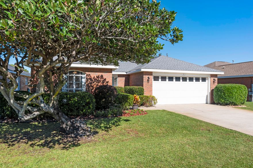 Charming one-level brick home with 2-car garage in Bayside, a great non-rental community in Miramar Beach close to the bay & beach! This home has beautiful curb appeal with nice landscaping and trees and a fantastic covered back porch and backyard offering true serenity. There are plentiful trees and added features like a garden trellis & shed. The interior offers 3 bedrooms and two baths with some unique custom updates like the beautiful white washed tongue & groove accent wall and elegant primary bath updates. The nice foyer entry opens up to a grand room with vaulted ceilings, gas fireplace & large sliders leading to a fantastic covered patio, an ideal spot for your morning coffee or to unwind at the end of day. There is updated flooring throughout with tile in the main living areas. There is an elegant dining area overlooking the whimsical backyard. If you fancy more casual dining, there is a breakfast bar for two. The kitchen has stainless steel appliances and artistic cabinet pulls and the 2-car garage is accessed off the kitchen. The primary suite is generously sized and features direct access to the patio, a large walk-in closet, trayed ceiling and impressive ensuite bath with updated Quartz double vanity, new cabinetry, elegant tile floors, large soaking tub for relaxing and updated tile shower with upscale tile, two niches and glass shower door. There are two guest bedrooms and a shared guest bathroom. The enhanced and fully fenced backyard has a picturesque garden feel and is a prime feature along with the tiled back porch. This home is being sold unfurnished but some items may be negotiable. Additional features include updated ceiling fans & light fixtures and bedrooms now have luxury vinyl flooring. This home offers easy maintenance with no carpet and roof replaced in 2022. It is also ideally in Flood Zone X. 

Bayside is a fantastic community with nice amenities including a swimming pool with sun deck, covered pavilion and picnic area, tennis courts, playground, and bayside park with a private dock access. Enjoy Bayside living, fishing, kayaking or paddle boarding from the community dock. Not only are you a quick stroll to the bay but you can even take a golf cart right to the beach. There is a great public beach access on Scenic 98 just 2 miles away from the home (across from Amalfi Coast), approximately a 4 minute drive! The beautiful Gulf of Mexico is easily within reach. You are also in a prime location to many dining, shopping and entertainment options with great restaurants right across Shore Drive including the new Bosforo, Commelfo's and Outcast Seafood. Silver Shells Premium Outlets and even Starbucks & Winn Dixie is just a mile away and a nice convenience and Pompano Joe's is just a 6 minute drive away (3 miles) and a local favorite for Gulfside dining, along with a beachside bar and plentiful parking for this public beach access. Don't miss out on this affordable, well-maintained home in a prime location in Miramar. 
