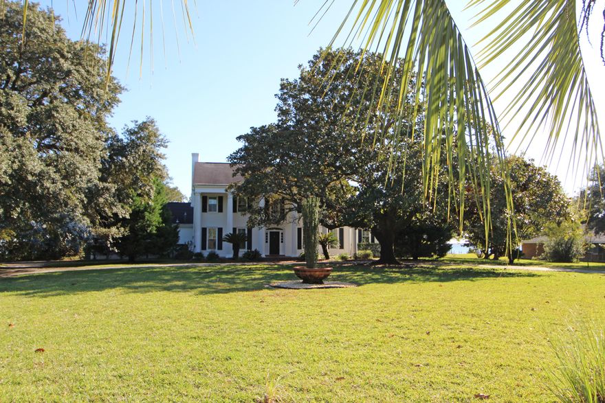 MAJESTIC WATERFRONT ESTATE SITUATED ON OVER 1 1/2 ACRES IN A PARK-LIKE SETTING WITH WELL MANICURED LAWNS AND MATURE TREES! Drive up your circular driveway and be greeted by a large covered veranda with columns. Enter the foyer with high volume ceiling and open staircase. Grand living room with lots of detailed wainscoting, crown molding, plantation shutters, center fireplace with mantle and french doors that lead out to the brick pavered patio with arbor. Den offers you another living space with built-in cabinets, a kitchenette, bedroom, and full bath perfect for guests or elderly parents. Dining room has chair railing and plantation shutters. Family room with built-in cabinets, entertainment center, desk, fireplace for those cool winter nights and French doors to your amazing waterviews.