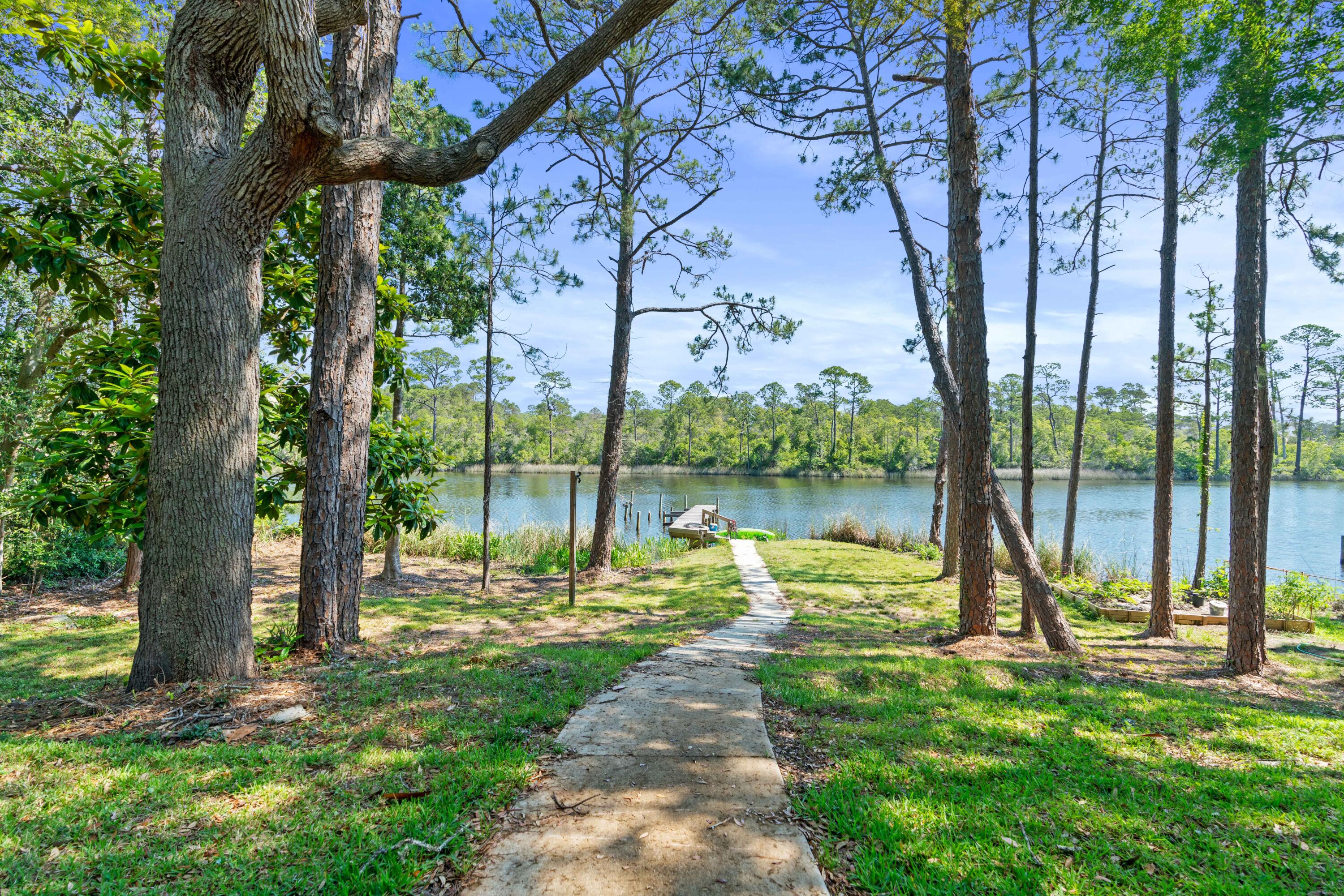 Investor's Dream! Don't miss your chance to enjoy all the advantages of Lake Powell waterfront living with easy access to all the great things the 30A beach lifestyle offers. Located in Inlet Beach, only five minutes from world class shopping and dining at 30Avenue, Rosemary Beach and Watersound Origins, this one-of-a-kind lakefront property is perfectly positioned on a private lot with over 157 feet of footage on Lake Powell, the area's largest coastal dune lake. Situated on .36 acres, this is one of the most private and largest lots in the area. This charming lakefront cottage offers four bedrooms, two full baths and the unique advantage of two full kitchens, one on each level. The upstairs living/dining area features a fireplace and custom dining table. Nestled under a canopy of live oaks and lush foliage, this unique property is situated on 1/3 of an acre with a private dock and 157' of prime waterfront footage on Lake Powell deemed the largest coastal dune lake in North America spanning over 800 acres and home to one of the most rare and unique fresh water ecosystems in the world.
Upstairs includes a newly remodeled full kitchen, stainless appliances, one-of-a-kind teak breakfast bar, open living/dining area with fireplace, built-in storage, two bedrooms, full bath that includes separate steam and shower, double vanities and half bath with hall access. Downstairs has two bedrooms, one bath and full kitchen.
Each of the bedrooms on both floors have breathtaking lake views and both floors have access to screened in porches that truly extends the outdoor living space. Two separate garages and extra parking space at end of driveway and street level make parking at this coastal retreat private and accessible. With the high functionality of a multi-purpose, income producing property, coastal lake front living at its finest and convenience of restaurants, high-end retail, and world-class beaches, this is a property not to be missed.
