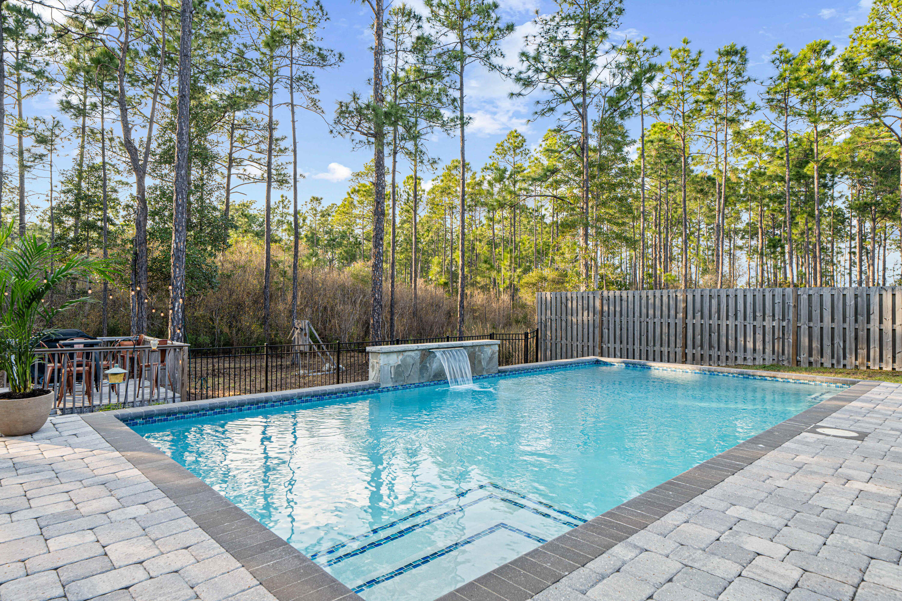 Incredible opportunity to purchase this renovated pool home that backs up to forest views! You won't find a better backyard at this price! Enjoy your own Florida oasis with saltwater pool surrounded by brick paver patio, fire-pit area, deck, and covered back porch. The lot extends into the forest, and there is plenty of room to play or entertain friends. The fence has a 10-ft double gate, making boat storage easy. Peach Creek is a charming neighborhood located minutes from 30A's sugar-white beaches, schools, restaurants, shopping, and is a short drive from iconic Seaside and Rosemary Beach. There is a new walking path perfect for outdoor activities, and food trucks often visit the neighborhood. Head to the beach, swim in the pool, or enjoy Florida living on the back porch. With tons of upgrades, including new quartz countertops in kitchen and bathrooms, luxury flooring, fresh paint, electric fireplace, new light fixtures and fans, custom built master closet, new faucets and more, this one-owner home is move-in ready. This well-designed "Victoria" floor plan features 4 bedrooms, 2.5 bathrooms, a large open living area, and 2-car garage. The beautiful foyer has wainscoting, new light fixtures, and cased-in doorways. The gourmet kitchen features a pantry with custom shelving, extra-large island for additional seating, quartz countertops, beautiful cabinetry with new cabinet pulls and handles, stainless steel appliances, and a spacious dining area with board-and-batten and cased windows. The living room has a fireplace with custom mantle, new ceiling fan, freshly painted walls and ceiling, and cased windows.
The Master Suite is beautiful and has an en suite with double vanity, soaking tub, tiled shower, wainscoting, and huge custom-built master closet with soft close drawers. The 3 guest bedrooms are nice-sized and separated from the Master Suite for privacy. Guest Bedroom 2 has a built-in desk and shelving. The Guest Bathroom has been remodeled and has a double vanity with quartz countertops and shower/tub combo with new shower head. The laundry room has been fully remodeled with cabinets, shelves, and luxury flooring. The half bathroom is renovated and features shiplap and high-end tile flooring. There is also a mudroom space off the garage. Additional features include SimpliSafe security system, irrigation system, privacy fence, 2-car garage with epoxy floors, gutters, and covered front porch. Schedule a showing today! Peach Creek is known for its holiday festivities, friendly residents, and unbeatable location. Can be sold furnished! Buyer to verify all pertinent information in listing.