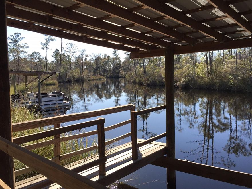 Scenic waterfront lot on a deep-water bayou, known as Alaqua, containing an existing boat dock and covered porch! Perfect homesite to build a fun cottage, perhaps a place to enjoy a ''fish camp'' away from home! Buyer must verify all information and specifications.