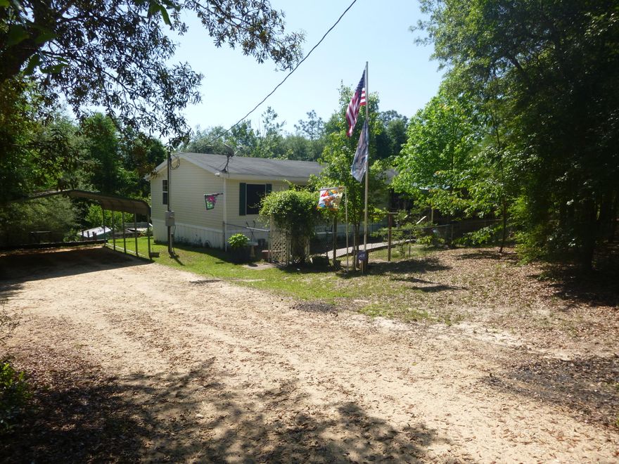 TURN KEY! Manufactured home on over 4.5 acres. All fenced with 4 ft privacy fence up front along with entrance gate. Home has large front porch, split floor plan, wood/ carpet flooring, and ADT security system. Skirt around the bottom of home is being replaced. Master bedroom has solar panel screens, walkin closet along with a study loft before you enter the bathroom. Master bathroom has two sinks separated by Jacuzzi. Two of the other three bedrooms do have walkin closets. One room is being used as an office with a built in desk. The room without the walkin closet has a built in bookshelf. There are two living rooms one by the front door overlooking porch and yard. The other has a wood burning fire place. The kitchen is very open with also a solar panel screen, reduces the electric bill.