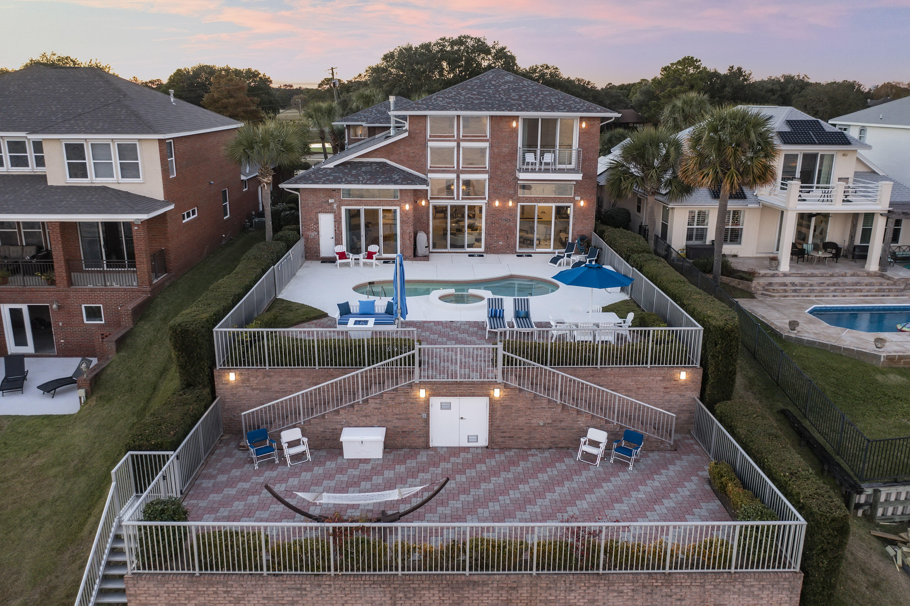 Prepare to be wowed by the views! This stunning all-brick, bayfront home is the complete package as it has it all! Offering the most spectacular and expansive Bay front views, this incredible luxury home offers a fabulous heated pool & spa w/ tiered patios, grill area & decks for entertaining, and fully equipped 660 square ft. guest apartment over the 3 car garage with its own entrance. The first level features soaring two-story tall ceilings, floor to ceiling windows with sliding glass doors, custom gas fireplace, custom made Italian draperies On the first level you'll find the primary suite with built-in bookcases, a huge walk-in closet, and an en-suite with glass bowl sinks, custom back-lit mirror and designer pendants. Offered fully furnished.