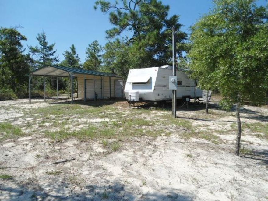 Need a place to camp out? Here are two lots with water tap and a 2005 camper 28' long and storage building.