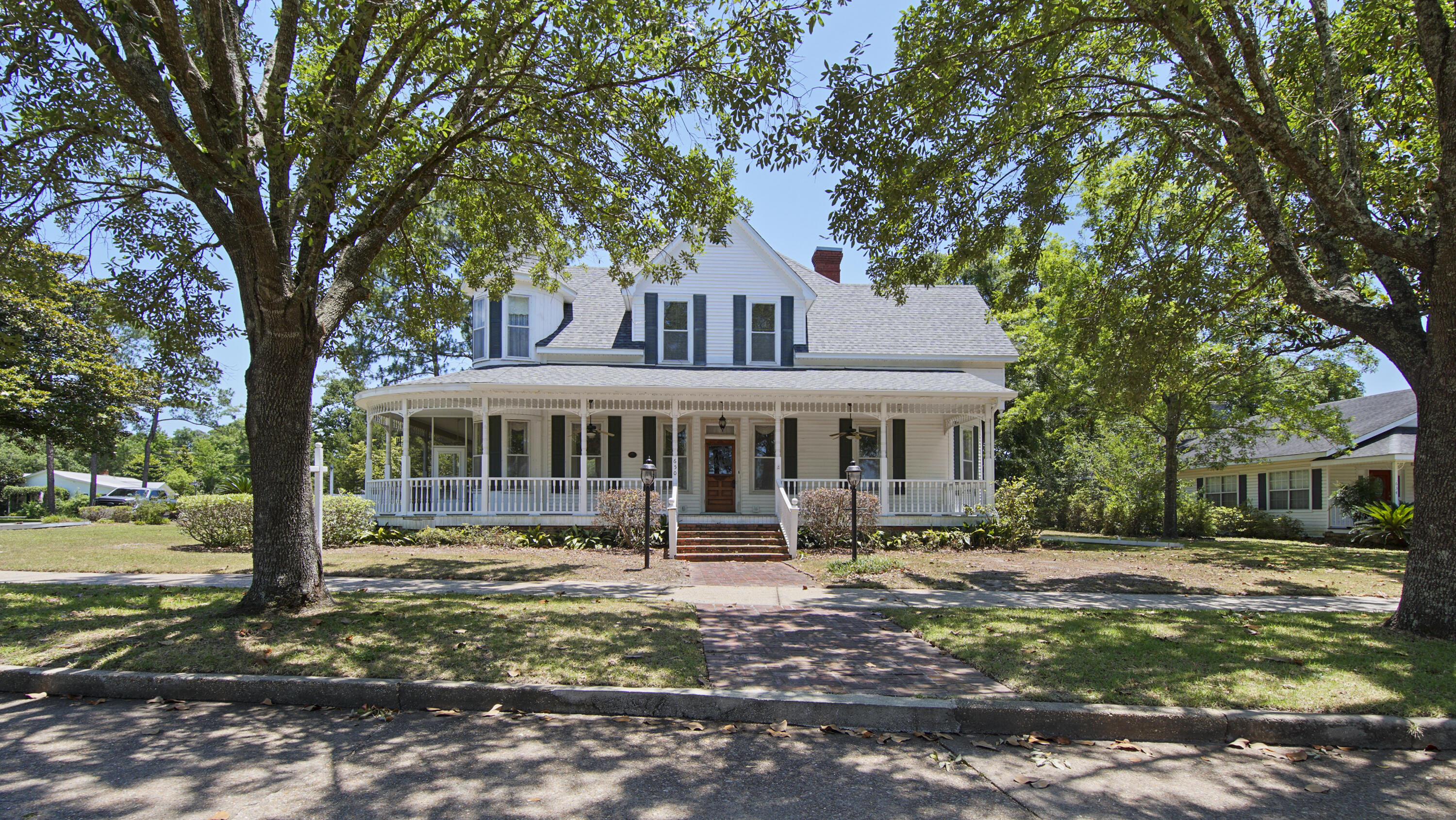 Spectacular Circle Drive Victorian, with many original features, and the breathtaking views of historic Lake DeFuniak with appx 110 waterfront feet. Just outside your front door is the mile-ish walking and biking paths/street around the lake, with sensational sunsets and less than a 1/2 mile to vibrant downtown. With 11' ceilings downstairs, refinished heart pine floors, all original windows+storm windows flooding each room with light. The back downstairs addition experienced a roof leak and has some paneling damage so the seller is having a new dimensional shingle roof installed for the new owner. There are multiple ways to configure the downstairs, which currently has one bed and bath. The included floor plan shows the large room sizes and your imagination can ignite your creativity. Options for both a downstairs OR upstairs master suite. If choosing upstairs, there is no comparable allure to that of the bedroom and the Lake-DeFuniak-facing adjacent sitting room, located inside the turret, one of this home's finest architectural delights. The upstairs has 9' ceilings with 3-4 additional voluminous bedrooms with one full bath. (Seller states that wood floors are underneath the carpeting.) There is baseboard heating and window units upstairs with central HVAC downstairs. This stately, exquisite queen has been in the same family for many decades. Who shall call 650 Circle Drive home?