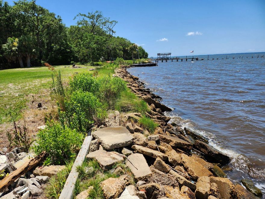 This unique Bay front property with 190 feet of waterfront and seawall is a must see! The majestic Oaks and full size Cypress trees as well as the established lawn make this a rare find. With almost 2 acres you can build a new dock for your boat and your dream home overlooking the bay and watch the sunset daily right into the water.