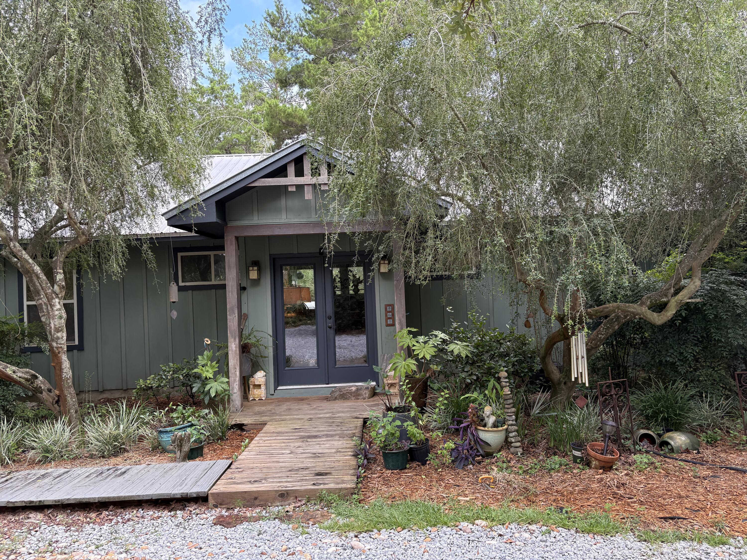 Peaceful, beloved 'one of a kind' custom Artisan home, well cared for; designed and built by the owner, Marti Schmidt, is tucked away in one of the most desirable and quiet areas of the authentic Point Washington Forest. The backyard boundary is 372 ft of the Forest. Nothing but nature surrounds this home. The large custom windows and cathedral ceilings allow for ample natural light throughout the home. There are hand-painted Raku Tiles around the fireplace and soaking tub. There are three stunning bedrooms, each with a private bath. The massive primary bedroom has a custom soaker tub and walk-in closet. There's a private screened porch for coffee or wine. Inspired by Frank Lloyd Wright, when designing the home, the Artist owner included custom walnut/maple furniture and cabinets built