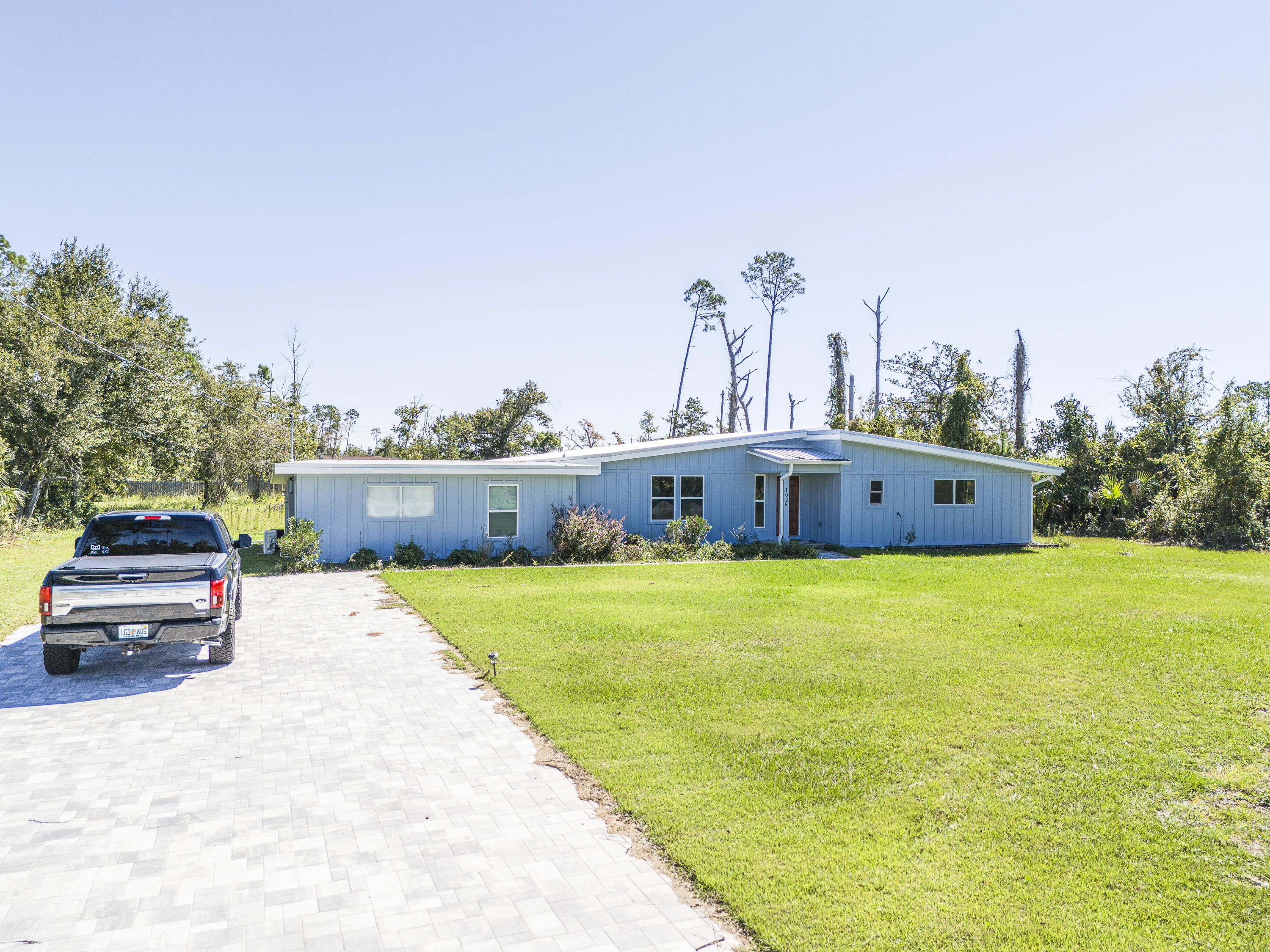 This fully remodeled 4-bedroom, 2-bathroom home sits on a sprawling 1-acre lot, just a quick 10-minute drive from Tyndall Air Force Base. The home's exterior boasts a brand-new metal roof with hurricane clips, fresh Hardie board siding, new paint, and updated windows. You'll also find all-new A/C, plumbing, and electrical systems throughout the house. Featuring a truly transformed interior featuring new drywall, modern light fixtures, switches, fresh paint, and durable LVP flooring. The kitchen is a is equipped with granite countertops and stainless-steel appliances. No detail was overlooked in this remodel, which essentially feels like a brand-new build. The county appraisers have updated the home's effective year to 2019.