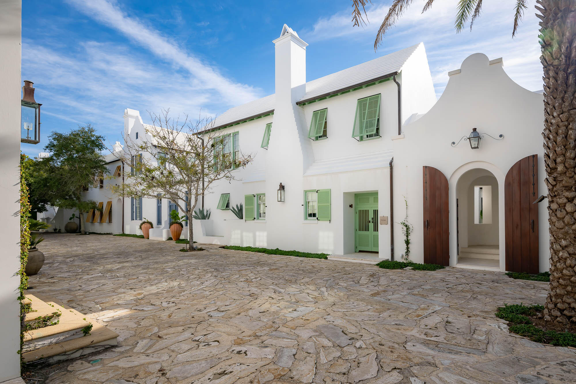 The Sea awaits with the offering of 23 Governors Court situated on the iconic Sea Garden Walk pedestrian path leading to the Gulf of Mexico.  ''Santigua'' as this home was formerly known was Alys Beach's original statement home.  Architect Gary Justiss created this masterful design embodying the original Alys Beach palette inscribed by the Bermudan & Antigua, Guatemalan architecture.Entering the courtyard lends itself to utter serenity accented by the grotto swimming pool and lone palm tree standing above the vibrant landscape.  Outdoor privacy integrates with indoor connecting the spaces by way of covered loggias for afternoon cocktails poolside.  The first floor encapsulates one's living needs having interconnected kitchen, dining, and living rooms boasting custom