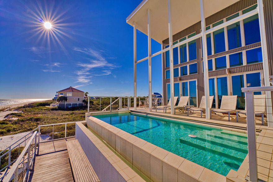Welcome to Sugar Sands Sanctuary, an exquisite Gulf front legacy home nestled in the gated community of The Plantation on St. George Island. Designed by renowned architect Carey McWhorter, this contemporary masterpiece spans over 5,000 square feet and boasts 100 feet of stunning beachfront on the Gulf of Mexico.From the moment you arrive, you are greeted by covered concrete parking and a spacious, enclosed foyer with an elevator for convenience. The first floor features an open living/dining/kitchen area with soaring two-story ceilings and walls of glass that provide breathtaking Gulf views. The elegant and serene decor, combined with comfortable seating, a flat-screen TV with a home theater system, and direct deck access, creates the perfect atmosphere for