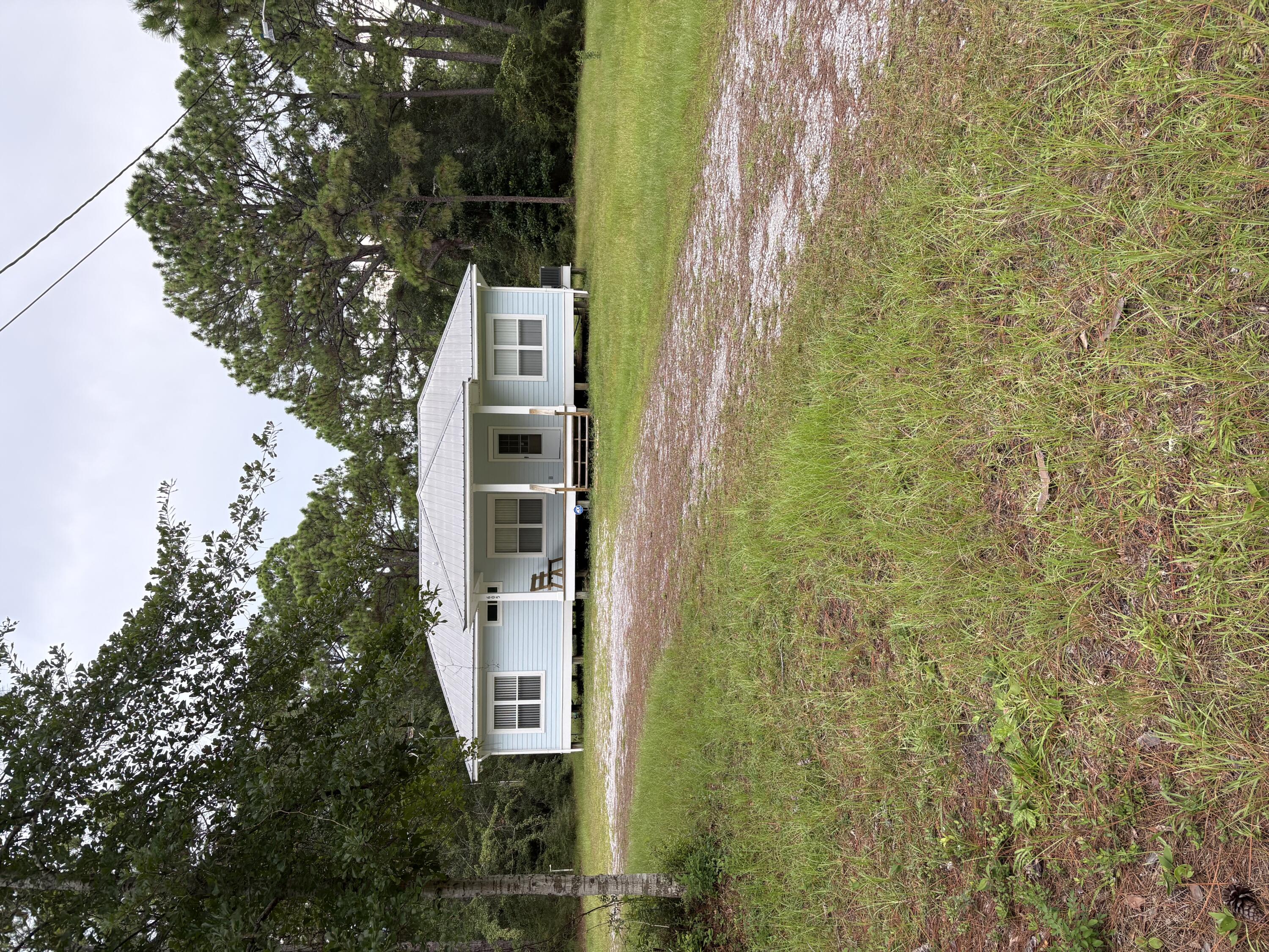 This charming Florida Cottage sits on 2.293 acres that consist of 8 platted lots. Relax on the front porch and enjoy the pleasure of a large front yard or retire to the back porch for a quiet siesta, listen to the birds' sing and enjoy the wooded surroundings. 3BR/2BA split bedroom design. Metal roof, hardy/board exterior provides long term minimal maintenance. Handicap access in rear and home is equipped with washer/dryer, large refrigerator, stove, and microwave. Central A/C & heat. Superb opportunity for that Builder/Developer to utilize these 8 platted lots in the fast developing South Walton.