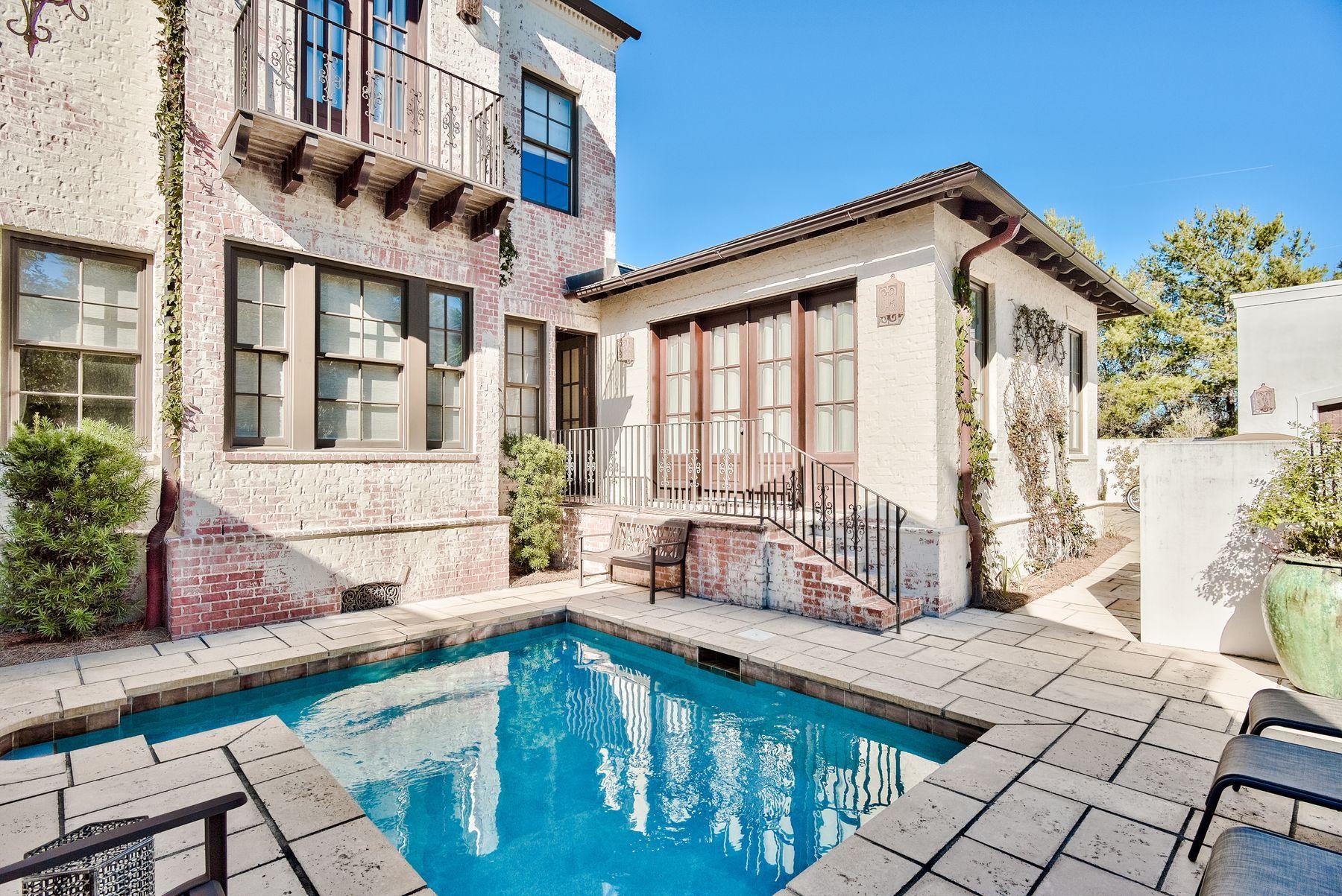 Legacy worthy luxury meets modern conveniences in this grand coastal retreat ideally situated on one of the largest lots in Rosemary Beach. With its plastered brick exterior and Spanish-inspired detailing, this elegant beach home offers unique finishes that are seldom found along the Emerald Coast. High-quality construction greets you immediately upon arrival, with custom iron door treatments and fixtures, antique terracotta tile flooring and repurposed pine beam accents imported from Canada.Designed with intention, the living spaces are open and bright. Expansive windows and 14-foot ceilings in the great room, which features a beautiful marble fireplace, feels airy and inviting. Just around the corner, create culinary treats in your own inspiring gourmet kitchen with high-end appliances