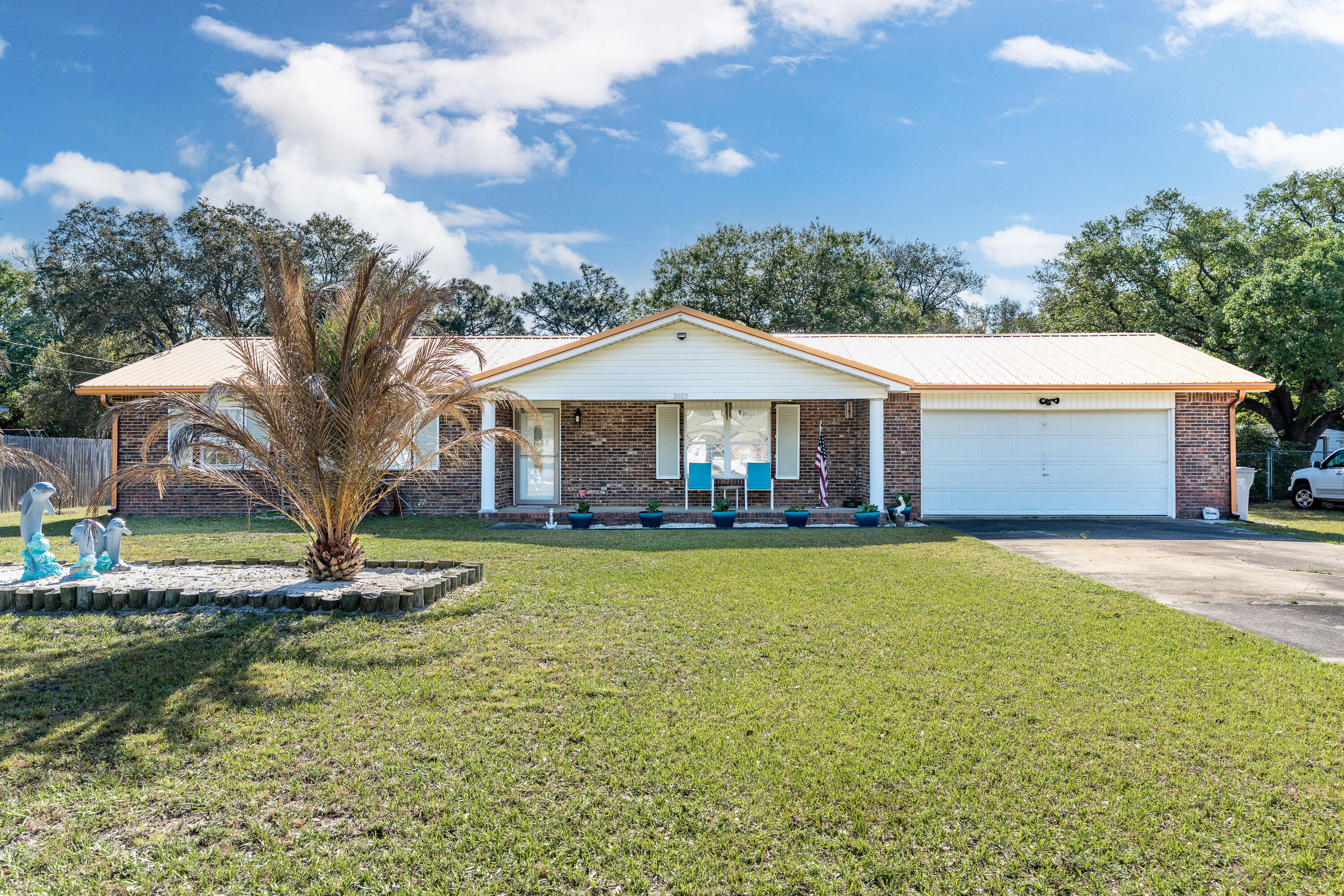 This cozy home has been rehabbed and is ready for its next chapter as a primary residence or investment. You're welcomed by a large yard and a driveway long enough for an RV *and* boat! The front door opens and it's all about light and bright. Grey porcelain tile runs throughout the home. The black granite countertops and stainless steel appliances in the kitchen add to the clean lines. The guest rooms are on the left side of the hall, with the full guest bath on the right side and the primary bedroom at the end with its own en suite. The massive back yard has a fire pit ready for you to enjoy, but there's plenty of room for a pool, outdoor kitchen, or maybe even a guest house. No HOA, no flood insurance required. Sellers are packing, pardon the boxes. Roof, WH, and HVAC all updated!