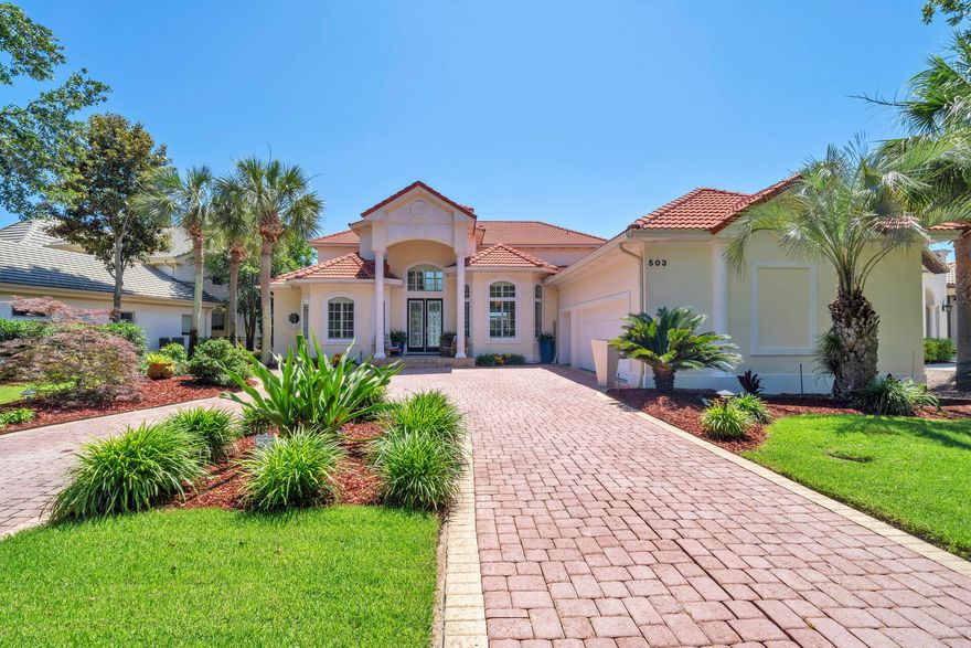 It's all about the VIEW! 503 Regatta Bay blvd is located lake front across from the 16th tee (no golf balls hit your home) in the prestigious Regatta Bay Lakes neighborhood.  This custom built home is excellent for entertaining with 20' ceilings, wide open spaces, a grand staircase, disappearing sliding glass doors that open on to the screened in pool lanai with non slip tile, hot tub, built in outdoor kitchen and plenty of room for seating that allows for al fresco dining while you watch the sunset nightly and fireworks 3 times a year bug free.  The pool bathroom helps keep water contained outside and comes with a shower to wash off the sand from the beach only 1.5 miles away.  There are door alarms for peace of mind with little ones too.  The gourmet kitchen has custom dovetailed