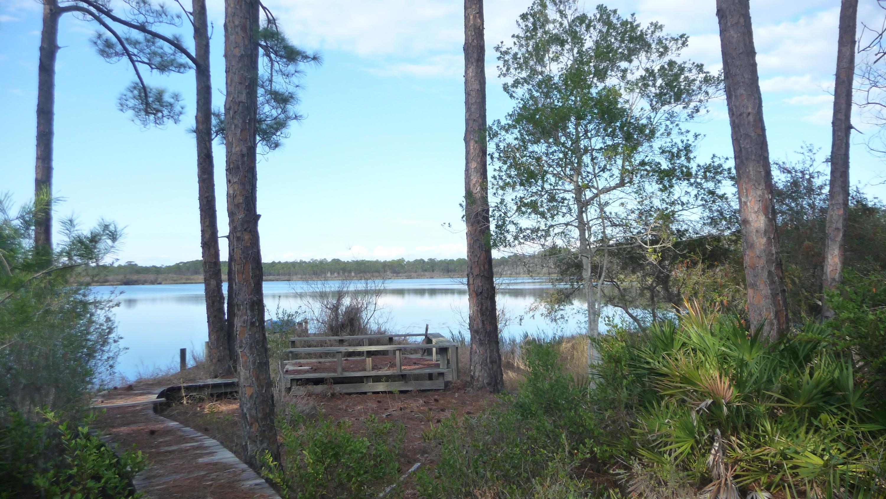 What a deal Estate Sale home on a 1+ acre lot! You will not find a lower price on a lake-front/gulf-view property of this size in all of South Walton. Ideally situated in the exclusive gated community of Four Mile Village, perfect for the buyer seeking privacy in a natural setting, yet so close to everything that Grand Boulevard and Sandestin have to offer. One look and you will see why the original owner held on to this property for over 30 years 135 feet on the lake with a dock, deeded beach access, hardwood floors throughout the 2nd floor, open LR/Dining/Kitchen, vaulted beamed ceilings, elevator, screened porches, and ample storage. With some TLC this property could be amazing, lots of great potential, being sold as-is. Please call today for your private showing appointmen