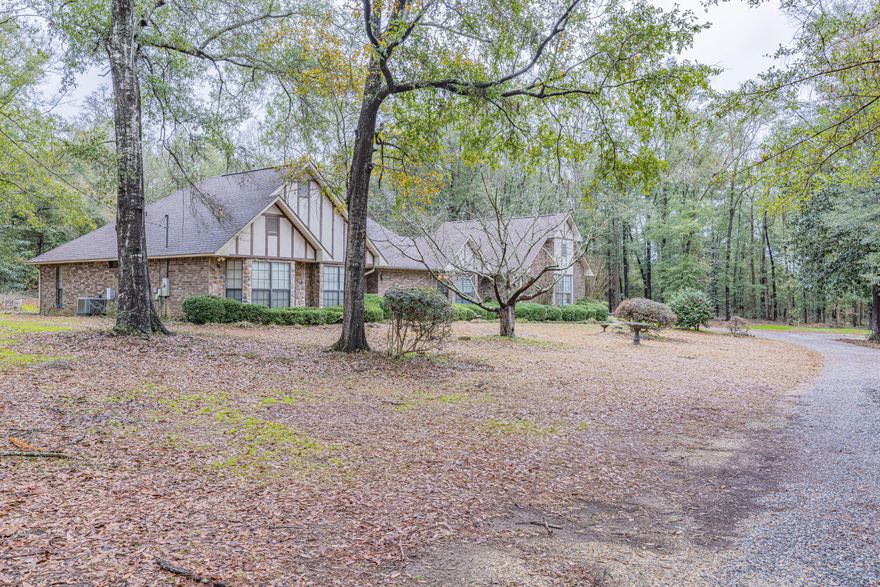 Perfectly situated on nearly three acres of land, this one owner, fully custom home is ready for you to come create a lifetime of memories! As you come down the gated driveway you are welcomed by a sprawling home nestled right along the tree line where deer often come for treats! 2024 Roof- 2024 Windows - Newer HVAC & Water Heater. Each and every detail of this home has been meticulously poured over with quality finishes including beautiful views from every room a gazebo tray ceiling in the dining room. As you enter the home you are greeted by your formal dining room and living room. The living room has direct access to the heated and cooled sunroom, a fireplace, high ceilings and a display ledge. The heart of this home does not disappoint and this kitchen is where everyone will want to be! Boasting ample countertops and cupboards, large peninsula island with seating, double oven, pantry and walk in laundry with additional pantry/storage space. Additional dining area in the kitchen has a perfect view of the grounds. Retreat after a long day to your luxurious master suite with tray ceilings, double walk in closets, direct access to the sunroom and an en suite that leaves nothing to be desired. All three bedrooms are generously sized and located together on one side of the home with a lovely guest bathroom. Seller says that during the spring and summer, this property is a beautiful green garden of plants and flowers! Bring the pets and kids because there is plenty of room to roam and have adventures, or there is a well thought out fenced in area just out of the kitchen window.