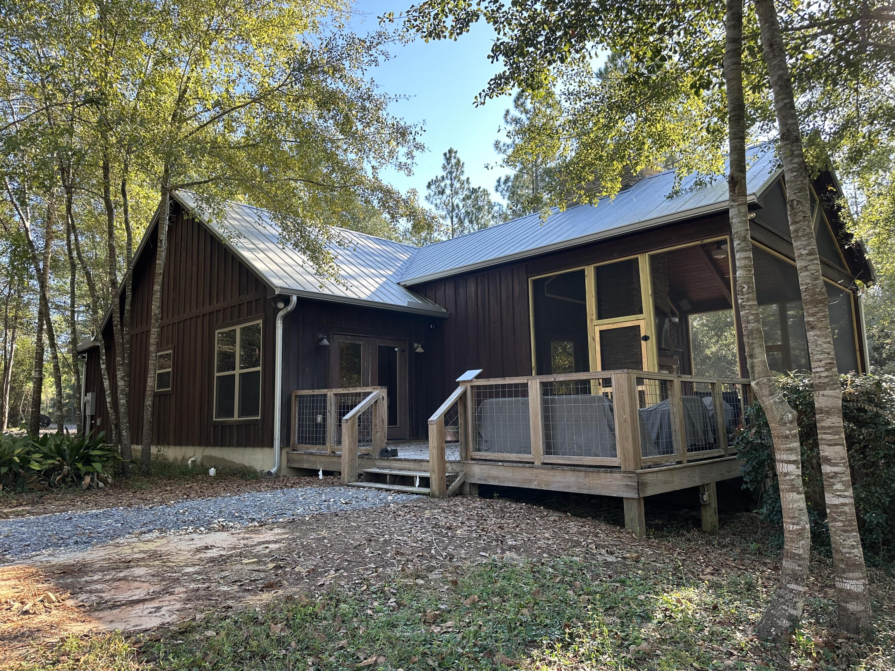 Modern Custom Cypress Cabin on 90 Acres - Turn-Key in Walton Plantation!Beautiful Florida-style cypress cabin on 90 acres, just 45 minutes from Gulf beaches. Features include vaulted cypress ceilings, 2 fireplaces, stainless appliances, large entertaining deck, barn with secure storage, orchard, and irrigated gardens. Miles of private trails for riding, walking, or exploring.Turn-key and ready to enjoy -- seller can include (2) 2022 four-wheelers, (1) 2024 four-wheeler, (1) 2024 side-by-side, and (1) 2024 commercial mower. Walton Plantation offers gated access, hunting, ATV riding, and more. The ultimate getaway for family fun!