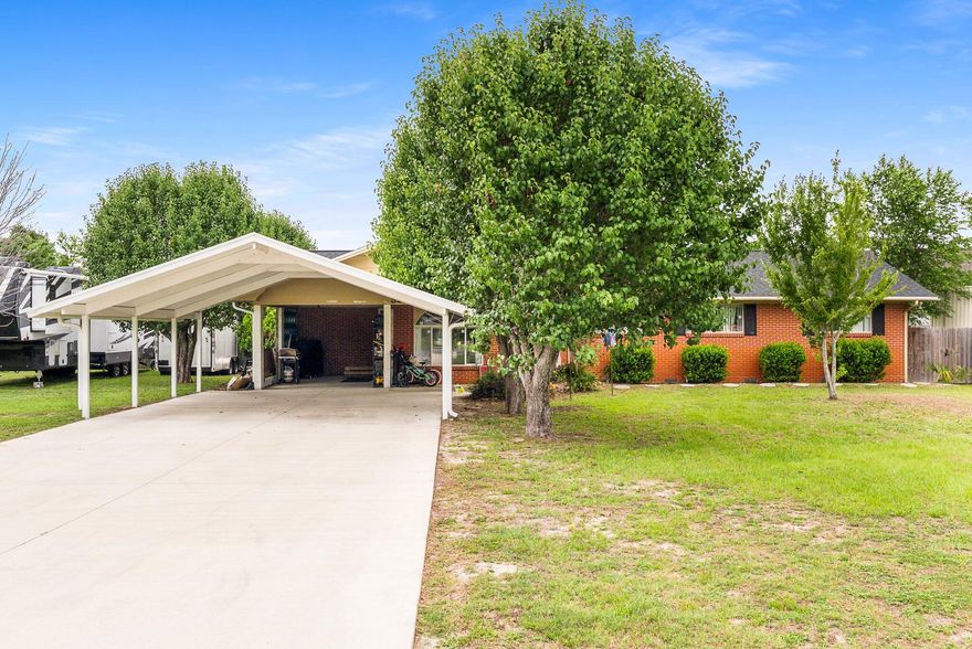 Welcome to your dream property! This beautifully maintained 4-bedroom, 2.5-bathroom home is situated on a generous 0.5+ acre corner lot and offers an incredible combination of comfort, functionality, and versatility. With three road access points, you'll enjoy ample parking for RVs, boats, and guests -- including a 50AMP RV charger and a carport for added convenience. Inside, you'll find gorgeous hardwood floors, two spacious living rooms, and a well-appointed kitchen featuring abundant cabinetry and a breakfast bar, perfect for casual meals and entertaining. The home's layout includes plenty of storage and was thoughtfully built on a crawlspace to provide extra durability and access. Step outside to your private oasis -- an oversized backyard.