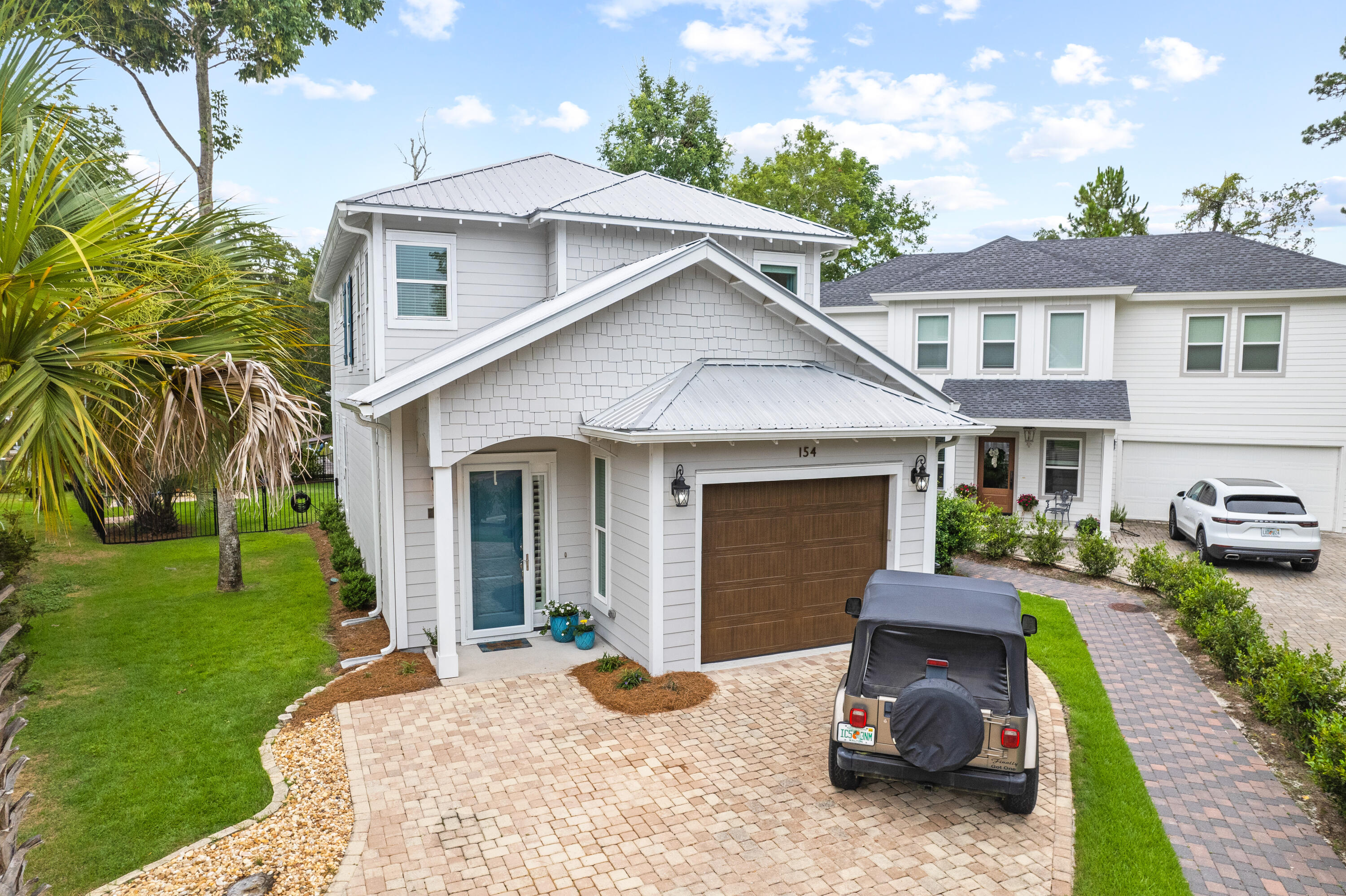 This beautiful, custom built home in the nature-rich community of Sacred Oaks is the perfect waterfront residence.  Primely positioned on one of the largest and most desirable canal-front lots in the community, 154 Rearden Way boasts an array of unique and notable features for modern living.  Characterized by coastal hues and sweeping porches, this 3 bed, 3 bath home offers an open layout, and showcases elevated finishes including tall ceilings and windows, granite surfaces, tile bathrooms and showers, stainless steel appliances, LVP flooring, tankless water heater, and craftsman style wood trim and decor along the walls and ceilings throughout. The first floor is comprised of a full guest room with ensuite bath, a built-in stairwell bookcase, and kitchen/living area with water views.