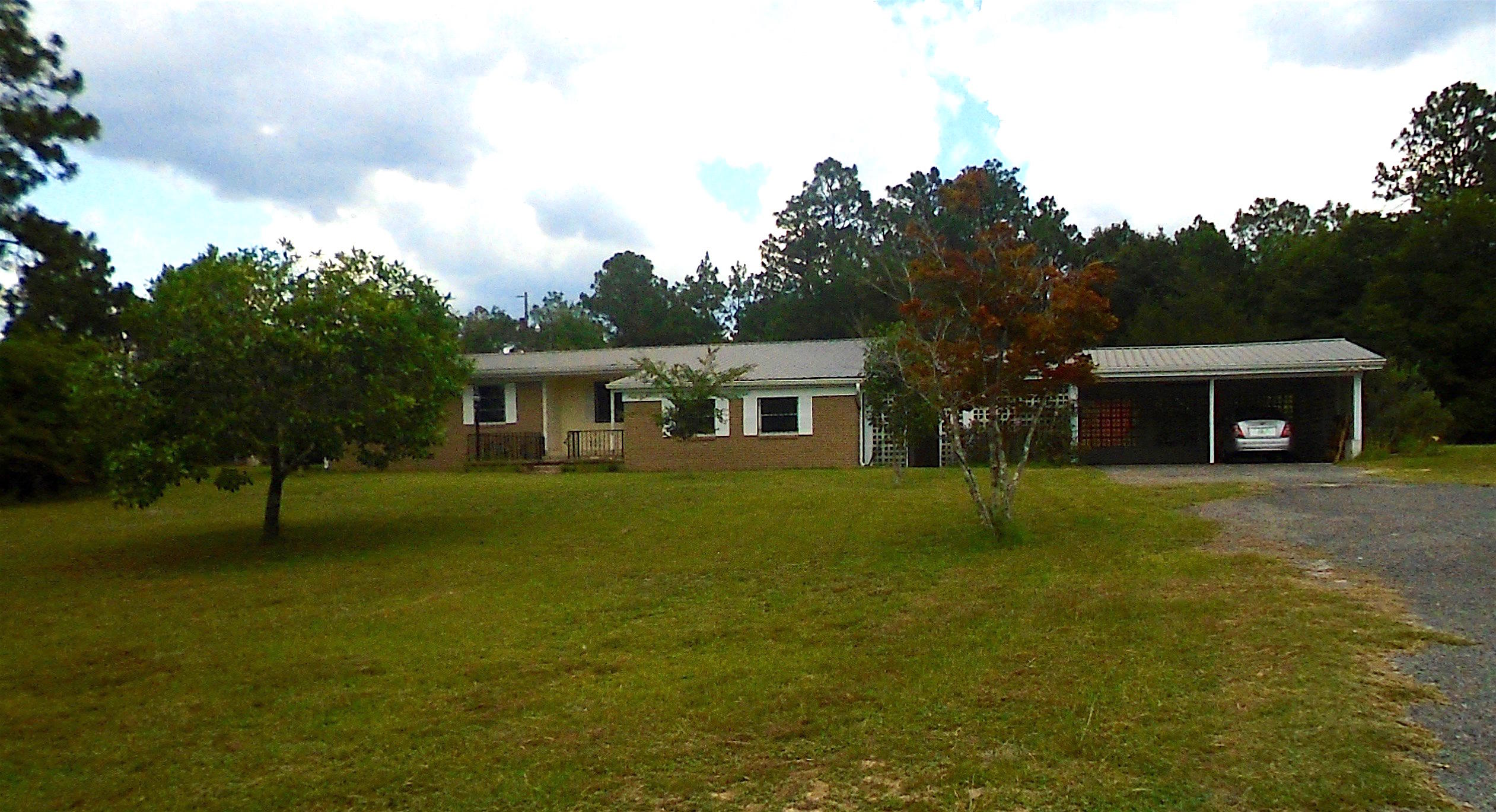 Looking for country living with the convenience of town? This is the property for you. Home is situated on three acres just minutes from city limits. It features an expansive family room with electric fireplace as well as a formal living room that can easily be converted to another bedroom or used as children's play area. Kitchen offers open floor plan to dining room/den area with spacious sun porch attached for the days you want to be outside but still want to enjoy the comforts of A/C. Hard wood floors and tile throughout and bathrooms have been updated for a more modern look. Large 12x18 utility room offers additional storage just off the family room. Property has a 14x20 workshop which is perfect for the handy man in your family. Roof replaced about 4 years ago.