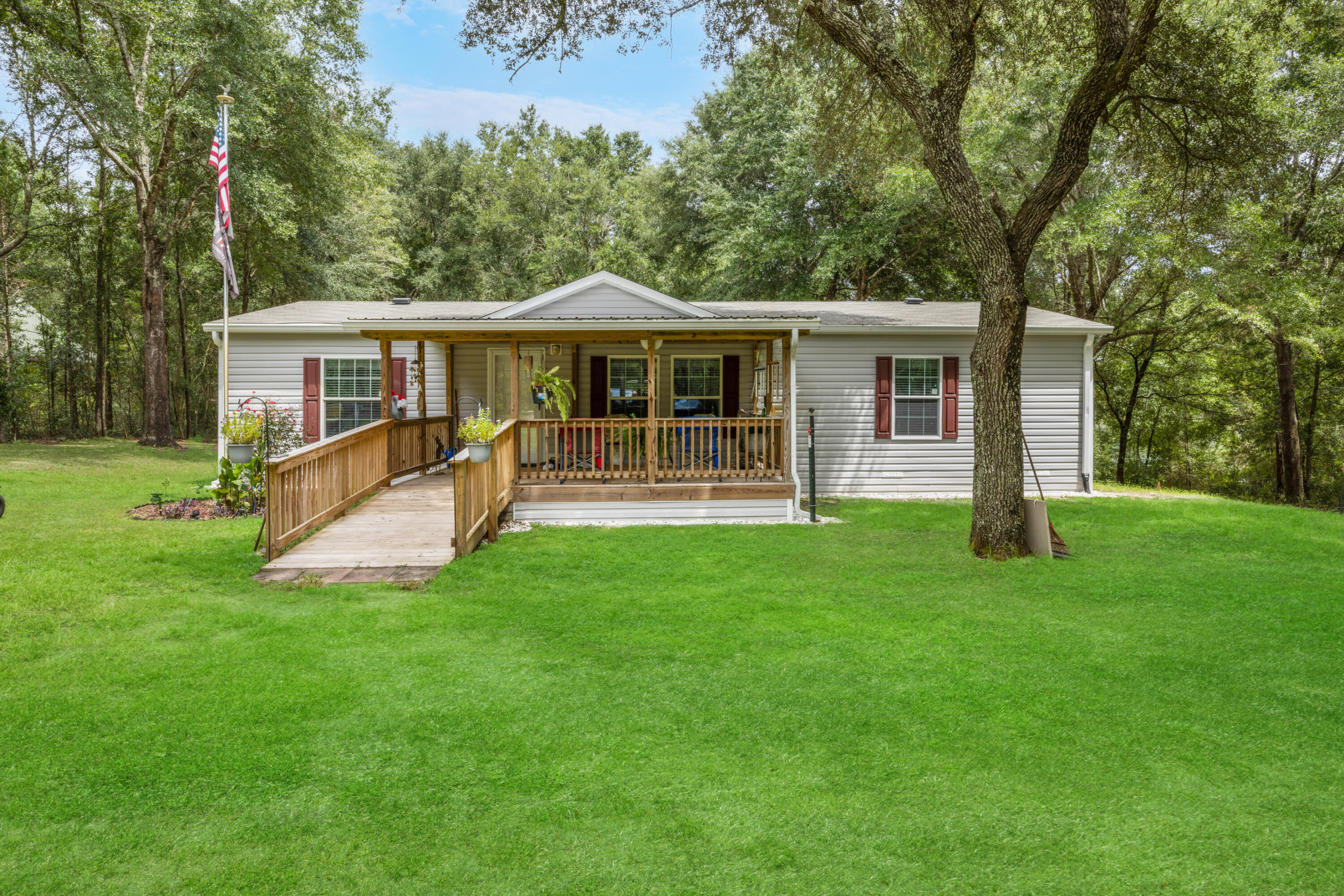 Come experience lakefront living in this beautiful 2019 home sitting on over 2 acres.  You will love the views, fishing and boating availability of Lake Holly.  This open concept home boasts a large living/dining area and a great kitchen as well.  The split bedroom floor plan is a bonus.  The open front porch offers views  of the front yard, birds, squirrels, rabbits and others.  The additional Florida room on the back of the home has amazing lake views, and common sightings of deer, fox, and even an owl from time to time.  The lake is full of bass, and this property has a beautiful dock/pier for your enjoyment.  Make your appointment today.