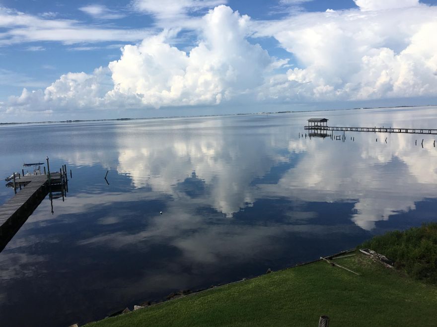 At the East end of Soundside Drive in Gulf Breeze is this one of a kind waterfront condo, over looking the Gulf Island Nat'l Seashore. With high ceilings, natural light, treasured views, and abundant wildlife, this truly is Paradise. The main living area includes the bedroom, bath, kitchen, living room and a large covered deck. Take the spiral staircase to the loft which is set up as an office, but is big enough to be a bedroom. There is a closet and access to additional finished attic storage. New hardwood floors, ceramic tile in both the kitchen and bathroom, large Jacuzzi tub, stainless steel appliances and upgraded kitchen cabinets. A private owners dock with electricity, water and short term boat parking. About 1/4 mile down Soundside is a public boat ramp