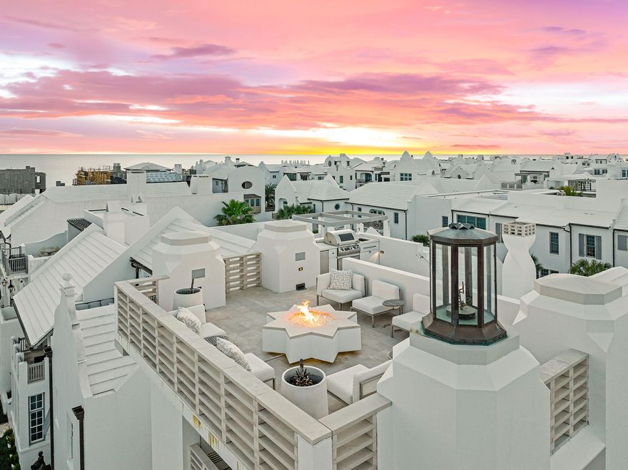 One More Day is a four-story, four-bedroom architectural residence designed by Khoury Vogt Architects, led by Alys Beach Town Architects Marieanne Khoury-Vogt and Erik Vogt. Created as a true gathering home, the directive was clear: deliver the firm's most refined and intentional design. The result is a residence defined by structure, precision, and a disciplined balance of Water and Fire throughout.Located one and a half blocks from the Gulf, the home anchors the southern end of The Parterre park along Sea Garden Walk, creating a direct visual and spatial connection between the home, the park, and the shoreline. Park views and town sightlines are preserved on every level, with Gulf views captured from the upper floors, including the fourth level. The entry courtyard establishes the home's architectural identity immediately. Rough Italian limestone zaguan walls feature integrated water elements, paired with a substantial limestone firewall illuminated by gas lanterns. A negative-edge pool wraps the courtyard, complemented by a suspended gathering pavilion and a mature Sylvester palm positioned as a focal point.

The main living level is designed for function and flow. Kitchen, dining, and living spaces open fully to the courtyard through an expansive sliding door system, creating a seamless indoor-outdoor environment. The living room features a coffered ceiling with curved wood inlays that discreetly integrate lighting, sound, and ventilation. Custom banquette seating spans the dining area, paired with antique mirror inlays and restrained crystal wall fixtures selected in collaboration with Bohlert Massey Interiors.

Italian limestone is used extensively throughout the home for durability and ease of maintenance. Interior floors feature large-format limestone tiles with a smooth finish, while exterior spaces incorporate textured limestone pavers and striated limestone railings along the upper loggias. Architectural details are consistent and intentional, including a sculptural white metal stair rail and an internally lit onyx sink in the first-floor powder room. The spiral chimney extends above the roofline, contributing a distinctive element to the town skyline.

The second floor includes the primary suite and two guest suites. The primary bedroom features a custom etched glass wall treatment, while the bath is designed with surrounding windows and stainless-steel bead curtains for controlled privacy. Amenities include a ceiling-mounted tub filler and integrated champagne refrigeration. Each guest suite includes an en suite bath, private balcony, and custom furnishings.

The third-floor sky loggia is designed for entertaining, overlooking Sea Garden Walk with filtered Gulf views. The space includes designer furnishings, retractable bead curtains, and a custom wood chandelier set against Venetian plaster walls.

The residence culminates at the fourth-floor sky terrace, accessed by a broad Italian stone staircase. Cantilevered above the town, the terrace offers expansive Gulf views, along with sweeping vistas across Alys Beach and the surrounding pine canopy. A limestone fire pit, summer kitchen, and built-in seating create a functional outdoor living space suitable for year-round use.

One More Day is a disciplined architectural residence where design, materials, and function are aligned. Purpose-built, visually strong, and positioned within one of Alys Beach's most prominent corridors, it represents a rare opportunity to own a true architectural property.