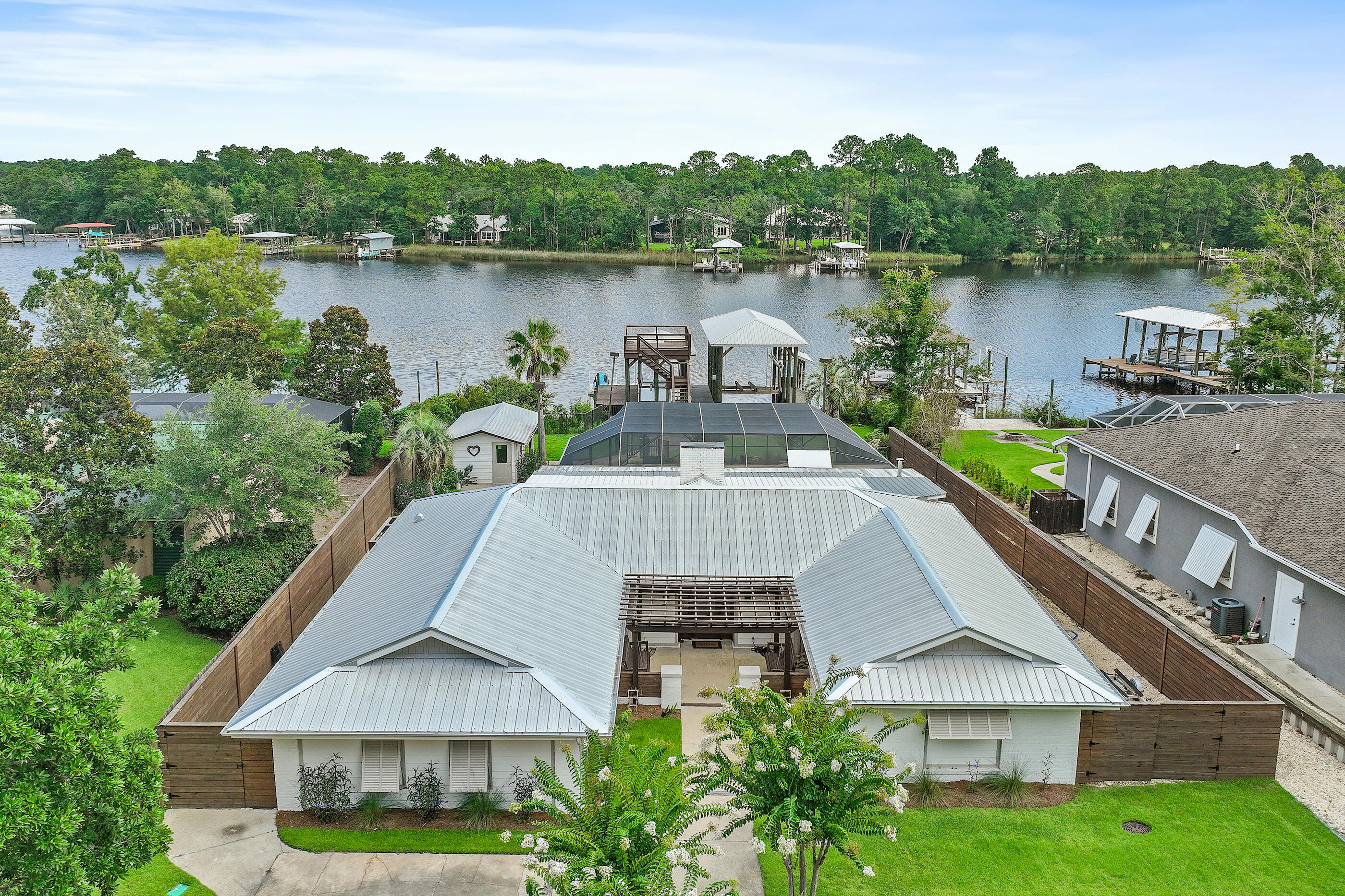 Welcome to your dream waterfront retreat on Mallet Bayou in Freeport. This stunning home was renovated in 2023 and offers luxurious upgrades throughout. The open-concept layout seamlessly connects the living, dining, and kitchen areas - ideal for hosting friends and family. The chef's kitchen is outfitted with premium Thermador appliances and highlighted by beautiful pecky cypress beams and custom accents. Whole house in-wall speaker system for the music lovers in the family! The spacious primary suite is truly unique, featuring TWO bathrooms. Outside, your personal oasis awaits: a sparkling pool, hot tub, and a fully equipped summer kitchen with refrigerator, ice maker and Big Green Egg. Two Boat lifts, two jet ski floating docks, and a second level Sunset viewing deck.