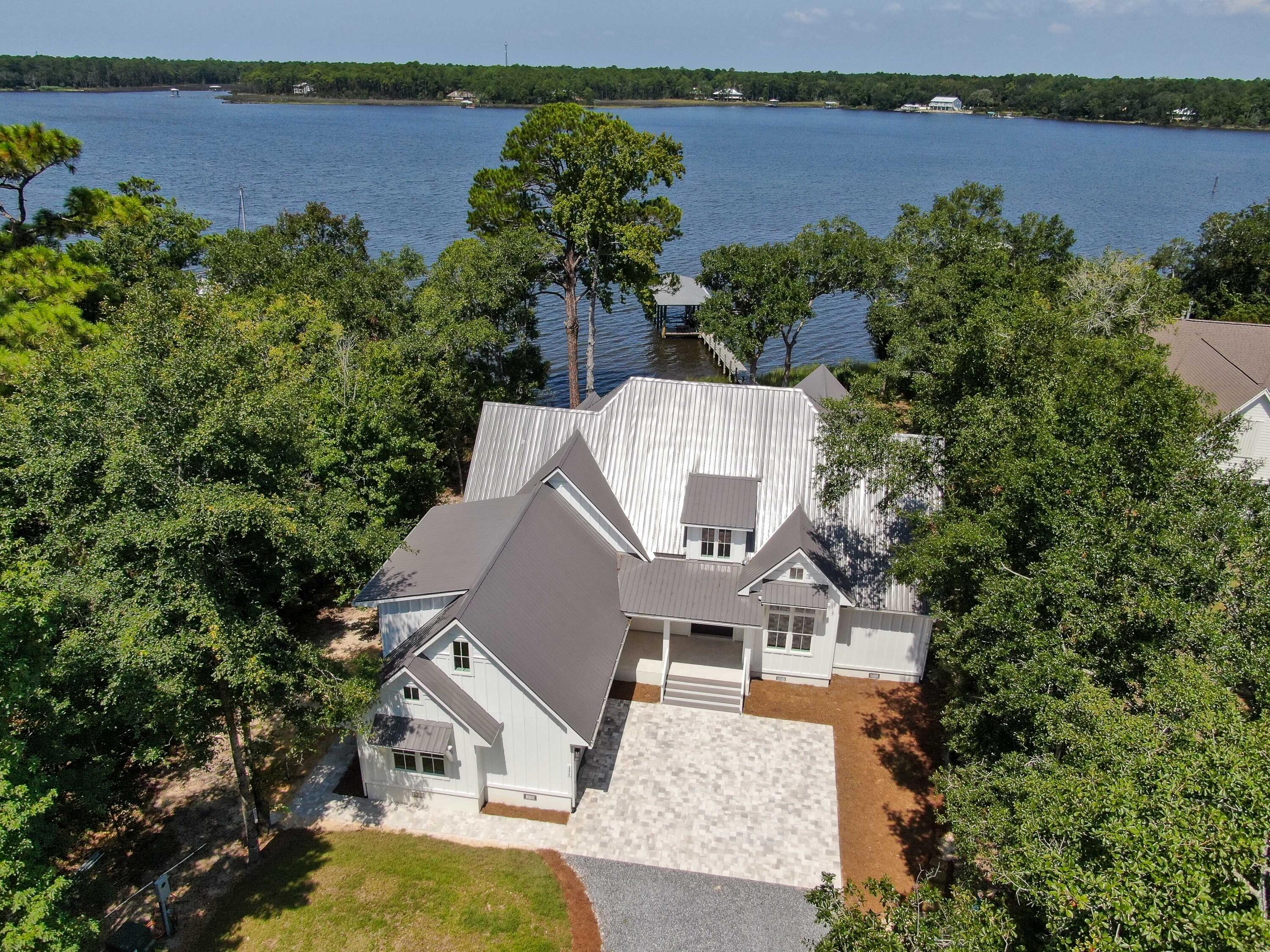 Introducing a brand-new custom waterfront home on the coveted Lagrange Bayou. This beautiful home is situated on a large private .79 acre lot with 108 feet of deep water bayou frontage that is navigable to the bay and the Gulf of Mexico. A covered boat dock with lift easily accommodates up to a 23' boat. The main level features 3 bedrooms, each with full baths as well as an office/4th bedroom. Upon entering the home, you are greeted by 16' vaulted cathedral ceilings and oversized sliding glass doors providing an unparalleled view of the water. You'll enjoy amazing sunsets throughout the house as well as from the large rear patio.