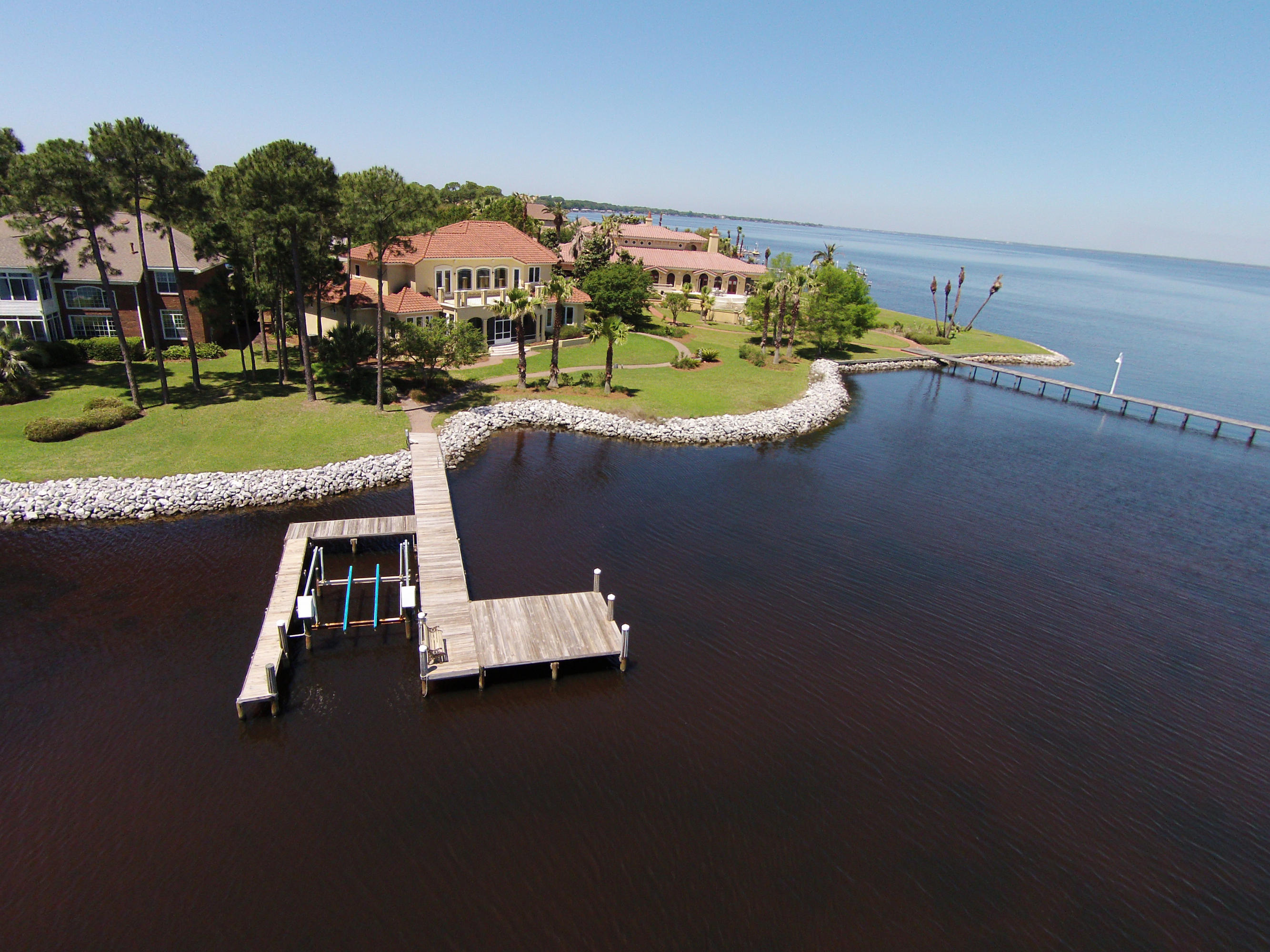 WATERFRONT dream home with 186' of waterfront with Dock & Boat Slip. Spectacular Mediterranean style home is situated on one of the best waterfront lots in Kelly Plantation and boasts water views from every room. Eastern water views, over the Bay, with the Mid Bay bridge in the distant horizon. This Premium Lot has Protected Waters, at the mouth of Jones Bayou, with open views of the Bay. The street is very private and shared by only a few other homes. Drive up the long pavered driveway to the oversized 3 car garage with plenty of space for guest parking. Lush tropical landscape compliments the mediterranean exterior featuring such details as window surrounds and triple double mahogany front doors. A covered front patio with courtyard gardens, along the entry,