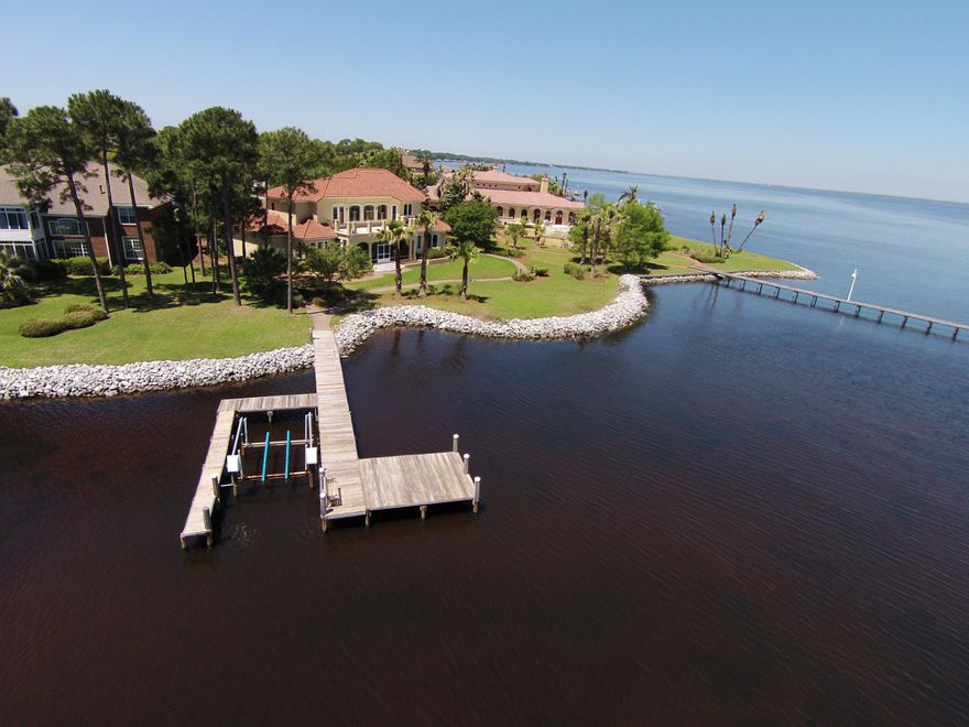 WATERFRONT dream home with 186' of waterfront with Dock & Boat Slip. Spectacular Mediterranean style home is situated on one of the best waterfront lots in Kelly Plantation and boasts water views from every room. Eastern water views, over the Bay, with the Mid Bay bridge in the distant horizon. This Premium Lot has Protected Waters, at the mouth of Jones Bayou, with open views of the Bay. The street is very private and shared by only a few other homes. Drive up the long pavered driveway to the oversized 3 car garage with plenty of space for guest parking. Lush tropical landscape compliments the mediterranean exterior featuring such details as window surrounds and triple double mahogany front doors. A covered front patio with courtyard gardens, along the entry,