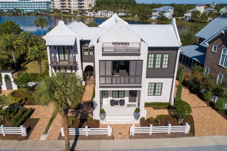 Stunning home on Lake Carillon and across Beachside Drive from the Gulf, this property consists of two lots, a large home, pool, garage, and English garden. There are 4 bedrooms and 4-1/2 baths, a 4-bunk room, a formal living and dining space with beamed ceiling, a kitchen with outdoor grilling space, and an art studio. Inside, but adjacent to the pool is a large den and wet bar. Lakeside is an expansive outdoor living space and pool along with an outdoor shower and powder room. On the second level, there is an outdoor screened living space off the master bedroom, overlooking the lake, and a large covered, shuttered porch on the front of the living room with Gulf views.. An open deck on the third level looks over the entire community, the lake, and the Gulf of Mexico. WOW!