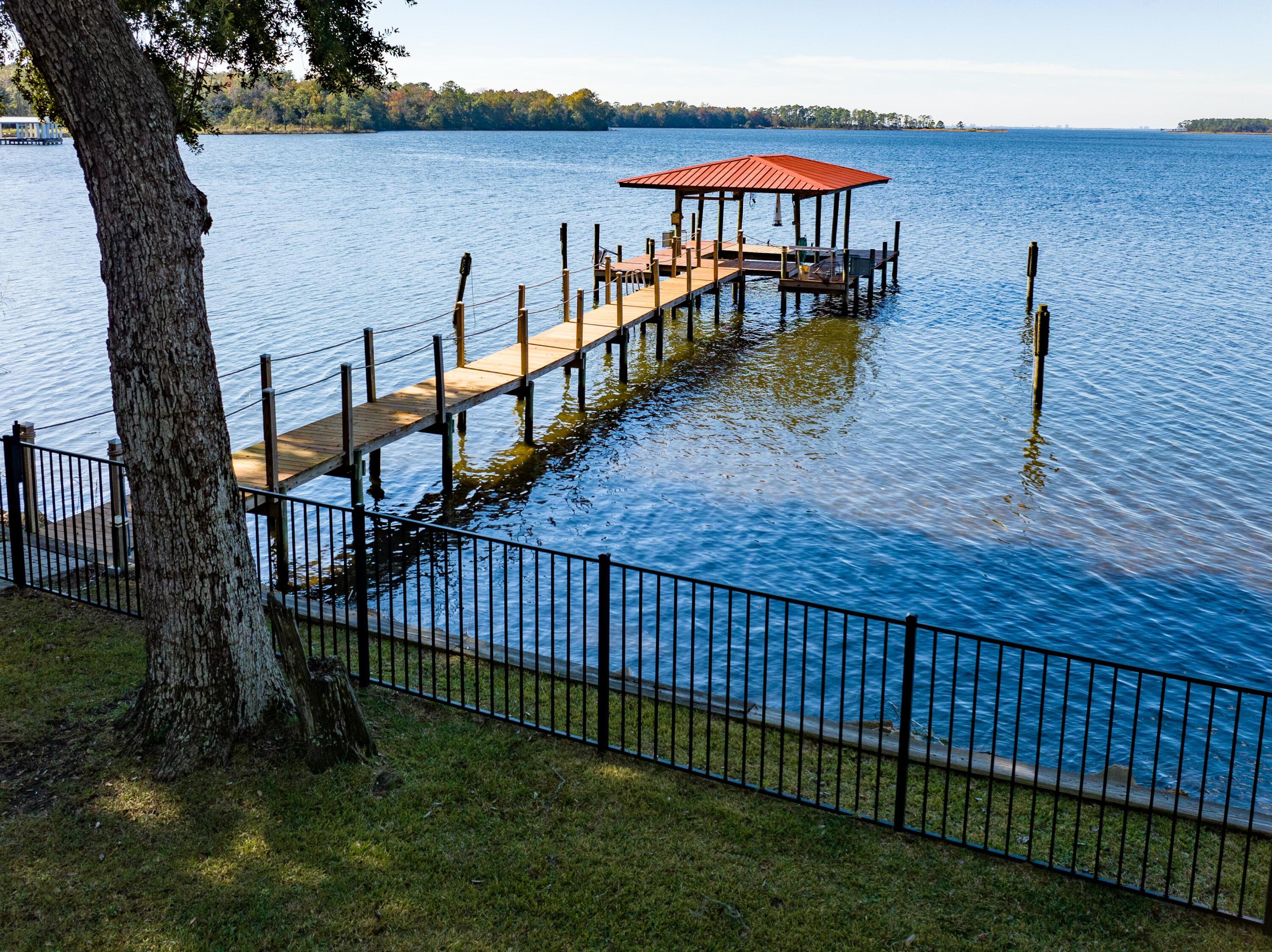 Nestled at a prime spot along the picturesque Alaqua Bayou in Choctawhatchee Bay, this extraordinary home boasts unparalleled views and stands as a testament to luxury living. Constructed with solid block, recent updates adorn the kitchen, bedrooms, floors, and stairwell. With water views from almost every room, this residence offers modern comforts in the serene embrace of Alaqua Bayou's protective Cove. Spanning over 3600 sq. ft., this haven features every imaginable amenity, including a fourth bedroom equipped with a kitchenette and laundry hook-up, and a second master with ensuite bathroom, and balcony access. The gourmet kitchen is a culinary delight, featuring a propane stove, oversize refrigerator, exquisite counters, and custom cabinetry.  Outdoor living reaches new heights (more)