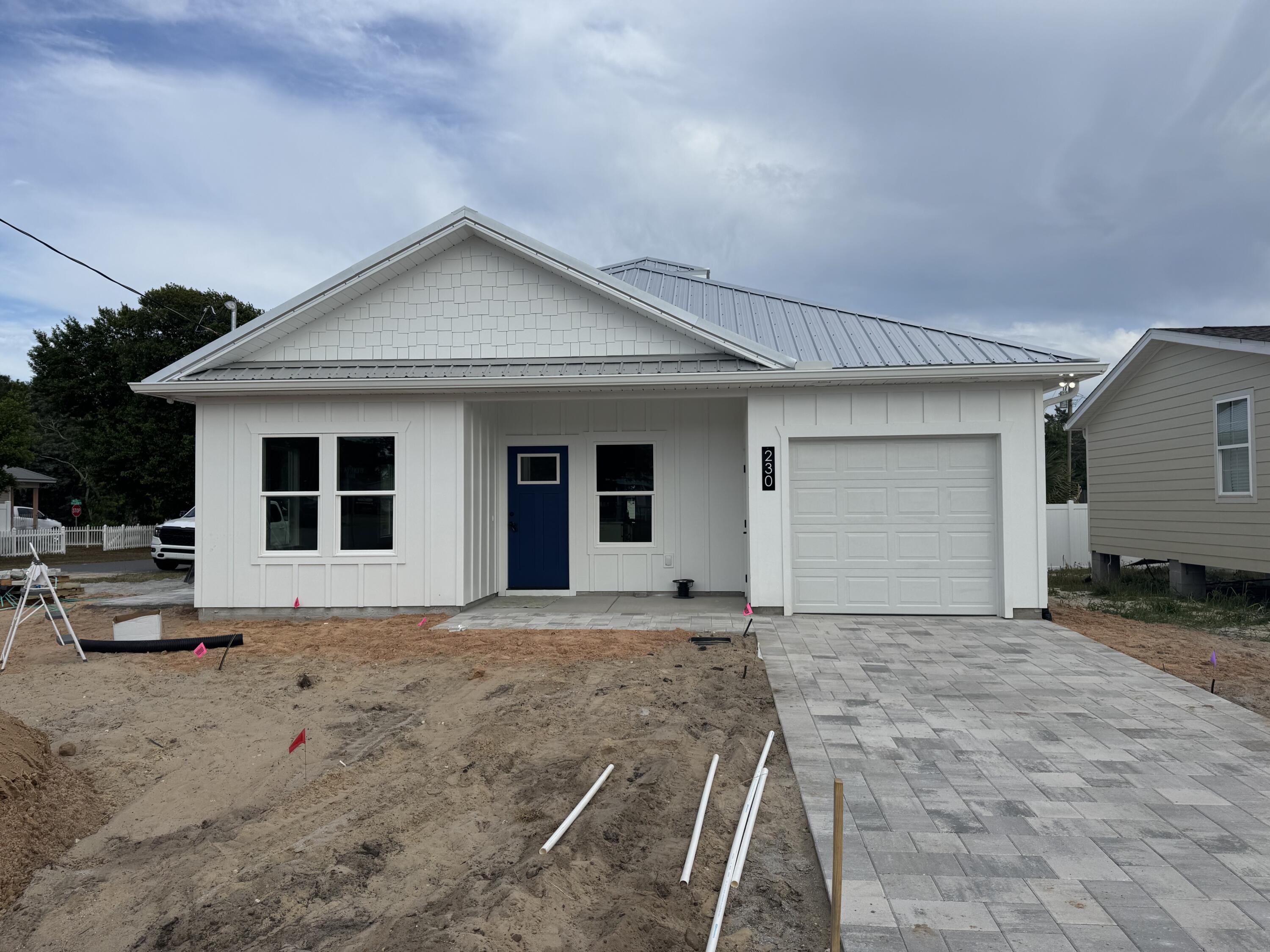Welcome to this stunning brand new construction beach home located in the heart of Laguna Beach on the West End of Panama City Beach, just two blocks from the pristine white sands and emerald waters of the Gulf of America and walking distance to Thomas Donuts. Positioned on a desirable corner lot, with a Gulf view from the front this thoughtfully designed home features two spacious bedrooms, two full bathrooms, a versatile bunk room, and an attached garage--perfectly blending comfort, function, and coastal charm. From the moment you arrive, the crisp white board-and-batten exterior, shake accents, and striking blue front door with paver driveway creates eye-catching curb appeal. A durable metal roof and impact-resistant windows provide both style peace of mind. The brick paver driveway and walkway enhance the entrance, setting the tone for the craftsmanship found inside. Step into a bright, open interior adorned with crown molding, shiplap accents, and detailed window trim. The kitchen is a showstopper, offering all-wood custom cabinetry with soft-close drawers, quartz countertops, a tile backsplash, under-cabinet lighting, and a full suite of high-end GE appliances.
The open living space is highlighted by a tray ceiling and soffit lighting creating elegance and architectural interest. Throughout the home, luxury vinyl plank flooring offers beauty and durability, while tile flooring in the bathrooms and laundry area adds a practical and polished finish. Both bathrooms feature matte black plumbing fixtures and modern styling. Step outside to enjoy a private brick-paver side patio, an outdoor shower for rinsing off after beach days.
Whether you're looking for a permanent coastal residence, a second home, or a high-return investment property, this beach cottage offers the perfect blend of quality construction, timeless design, and an unbeatable location just steps from the Gulf.