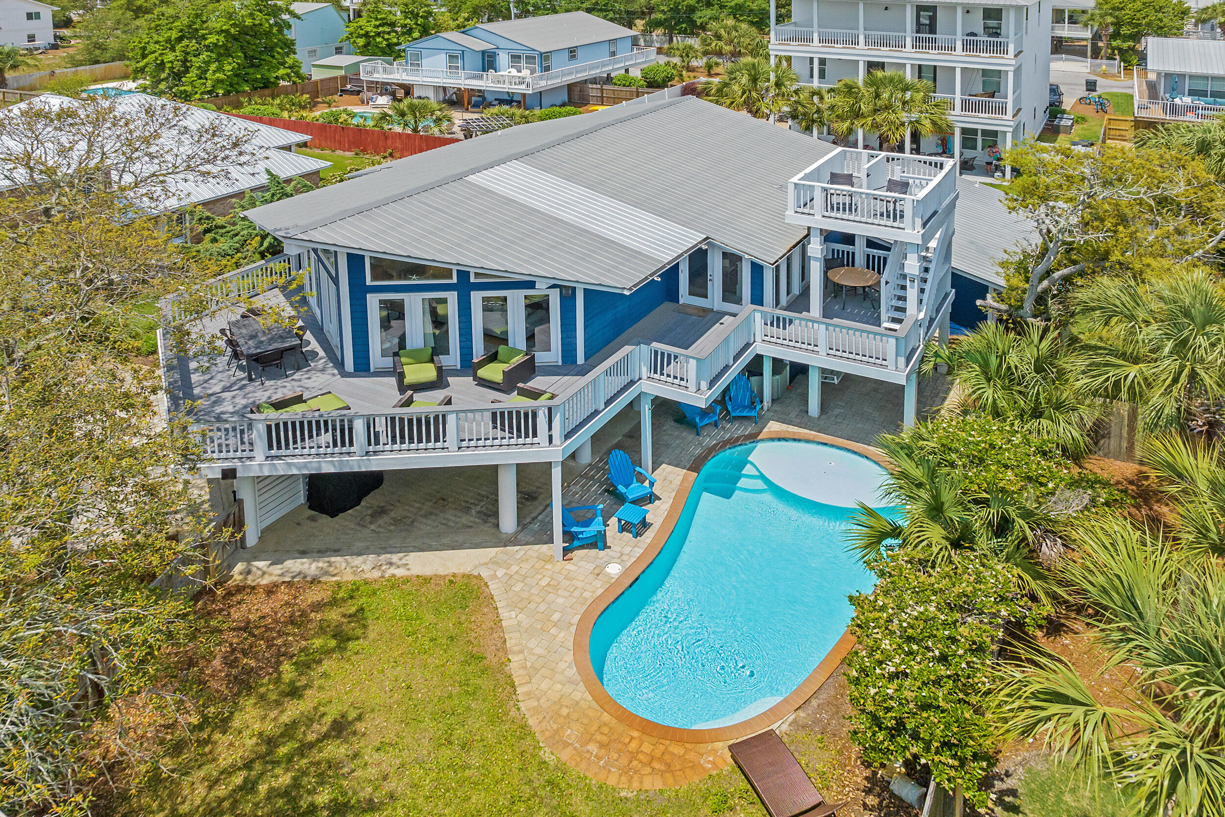 With an air of mid-century style, this charming South of 30A beach retreat offers privacy on a large lot, only moments from the Gulfview Heights Regional Beach Access. This property provides plenty of space for large groups to spread across--with 5 bedrooms, 4 bathrooms, two living areas, a second-floor deck that runs along the architecture of the home and leads to a crow's nest deck with a glimpse of the Gulf, and two fenced-in yards. One area is privatized in the front, surrounding the heated pool, the other is out back, with a patio-sitting area. Beautiful live oaks offer a parklike atmosphere in front. Indoors, enjoy an open living, dining and kitchen area with a vaulted ceiling and walls of windows. Downstairs is the second master suite and recreation room with pool table and wet bar. The home has two sizeable outdoor storage lockouts for beach gear; one is a small garage. With the large bunk room, this home can accommodate groups of up to 14.
At the end of Betty Street, turn left to enjoy the Gulfview Heights Beach Access, providing parking, restrooms, showers, sheltered picnic tables, and lifeguards during peak season. 95 Betty St is approximately 350 yards to the sand.
Betty Street offers privacy away from it all, with just 28 homes on large parcels and a dead-end, there will be limited drive-through traffic.
No HOA fees or added restrictions means freedom of ownership and opportunity for creative growth and expansion.
The home is just under 3/4 a mile to the shops and restaurants at the intersection of 393 and 30A, including, Papa Surf Burger Bar, Shunk Gulley, Growler's Garage (Craft Beer), Pecan Jack's Ice Cream, The Perfect Pig and other Gulf Place amenities.
If you are looking for a South of 30A beach home with character and an incredible, private location, 95 Betty Street belongs on your list of must-see properties.